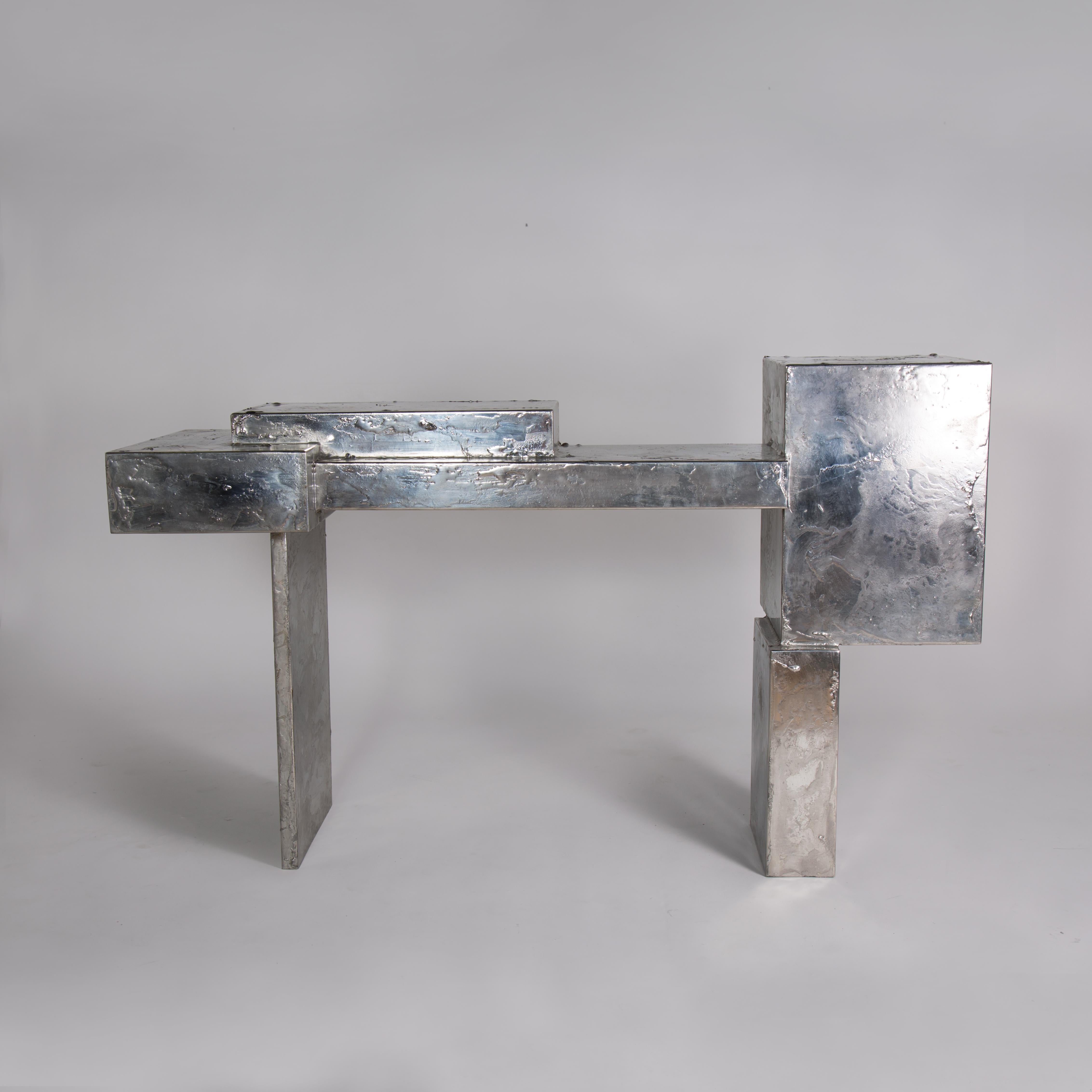 Pewter console by Gentner Design
Dimensions: D 137 x W 43 x H 84 cm
Materials: pewter on steel.

The Pewter Collection is a family of furniture pieces defined by their materiality and formal qualities. One Crucible at a time, pewter is melted