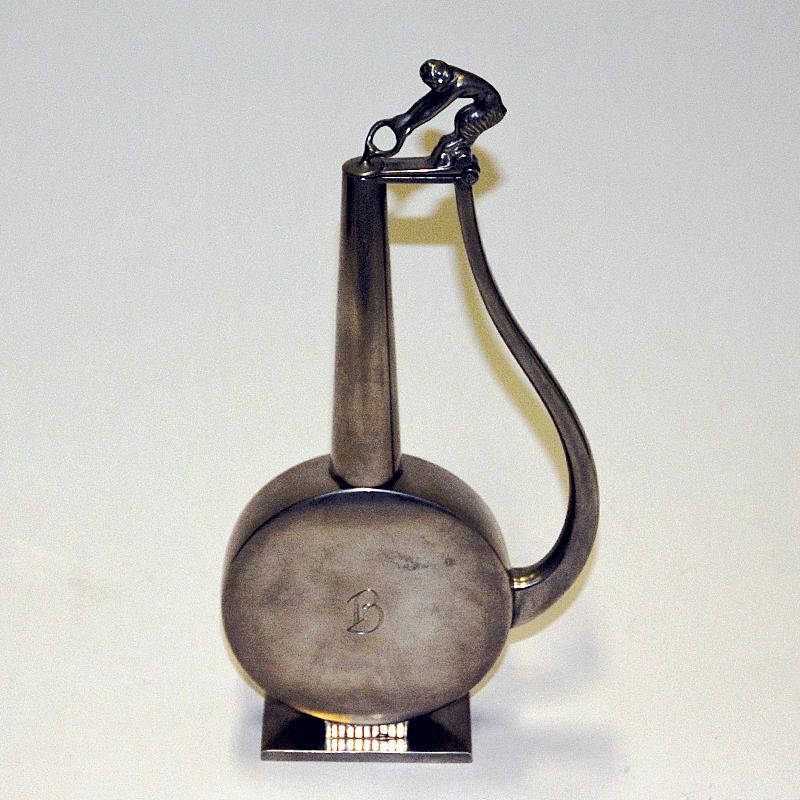 Seltener und schöner schwedischer Zinnkrug von GAB Tenn, Schweden 1933. Ein speziell entworfener Krug mit einem Faun-Deckel aus Zinn auf der Oberseite. Der Krug hat einen runden Körper mit einem langen Hals. Formschöner Griff. Perfekt und besondere