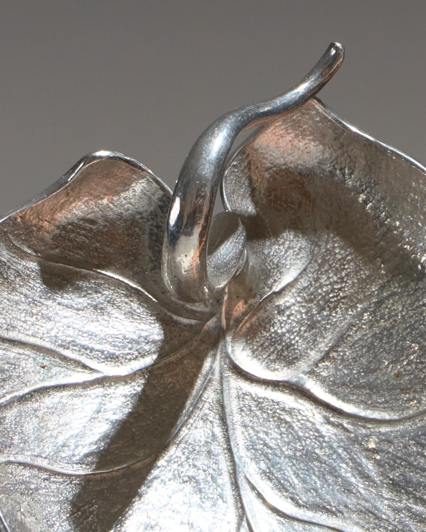 Vide-poche en étain, moulé en forme stylisée de feuille, typique de l'esthétique Art Déco. Estampillé Les Étains du Manoir, une manufacture française particulièrement active entre les années 1950 et 1970, et reconnue pour ses objets en étain. Bon