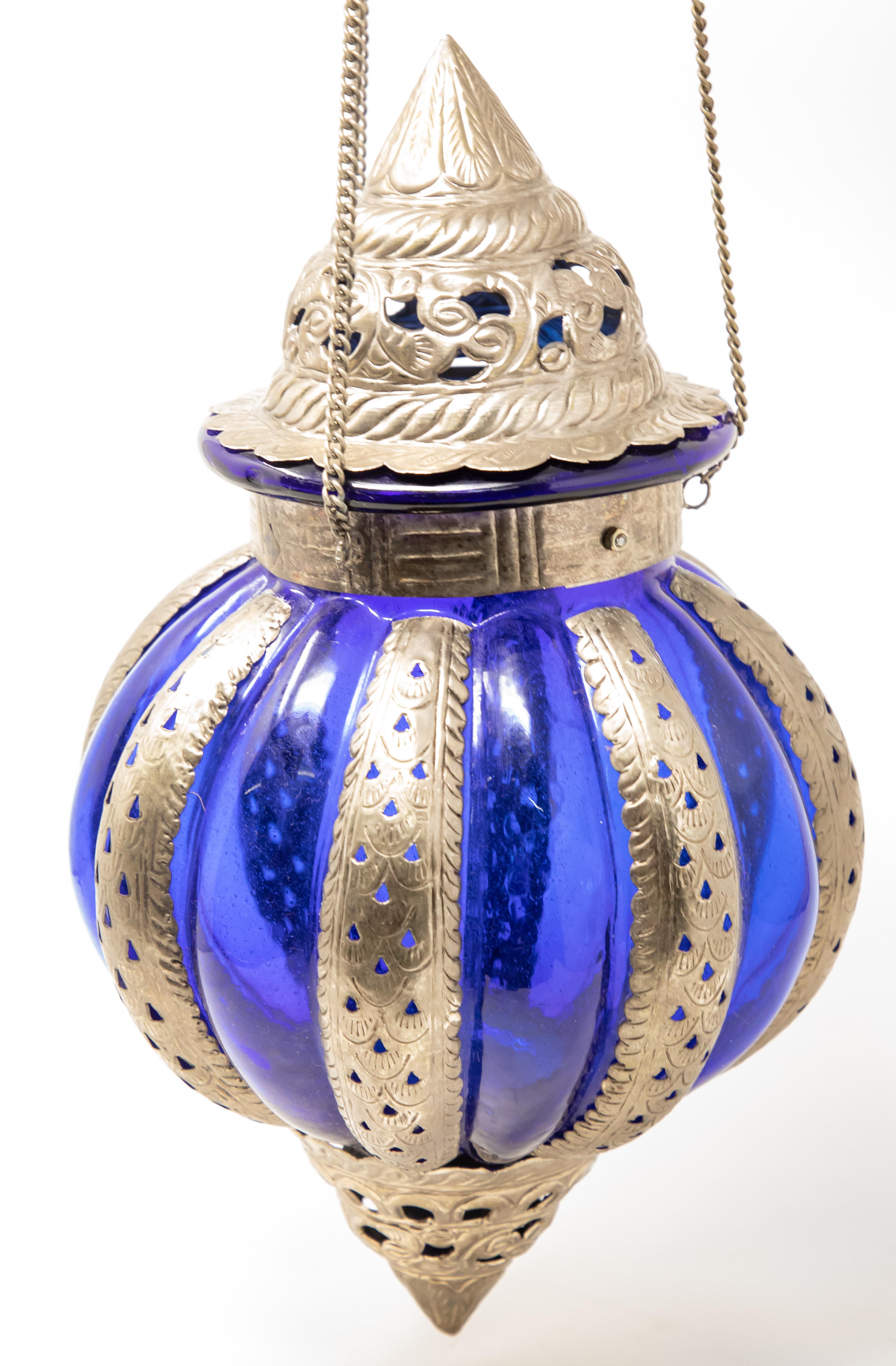 Offering this Moroccan lantern made of pewter with openwork detail. A cobalt blue glass makes the pewter stand out. This lantern is not wired and is meant for use with tealights.