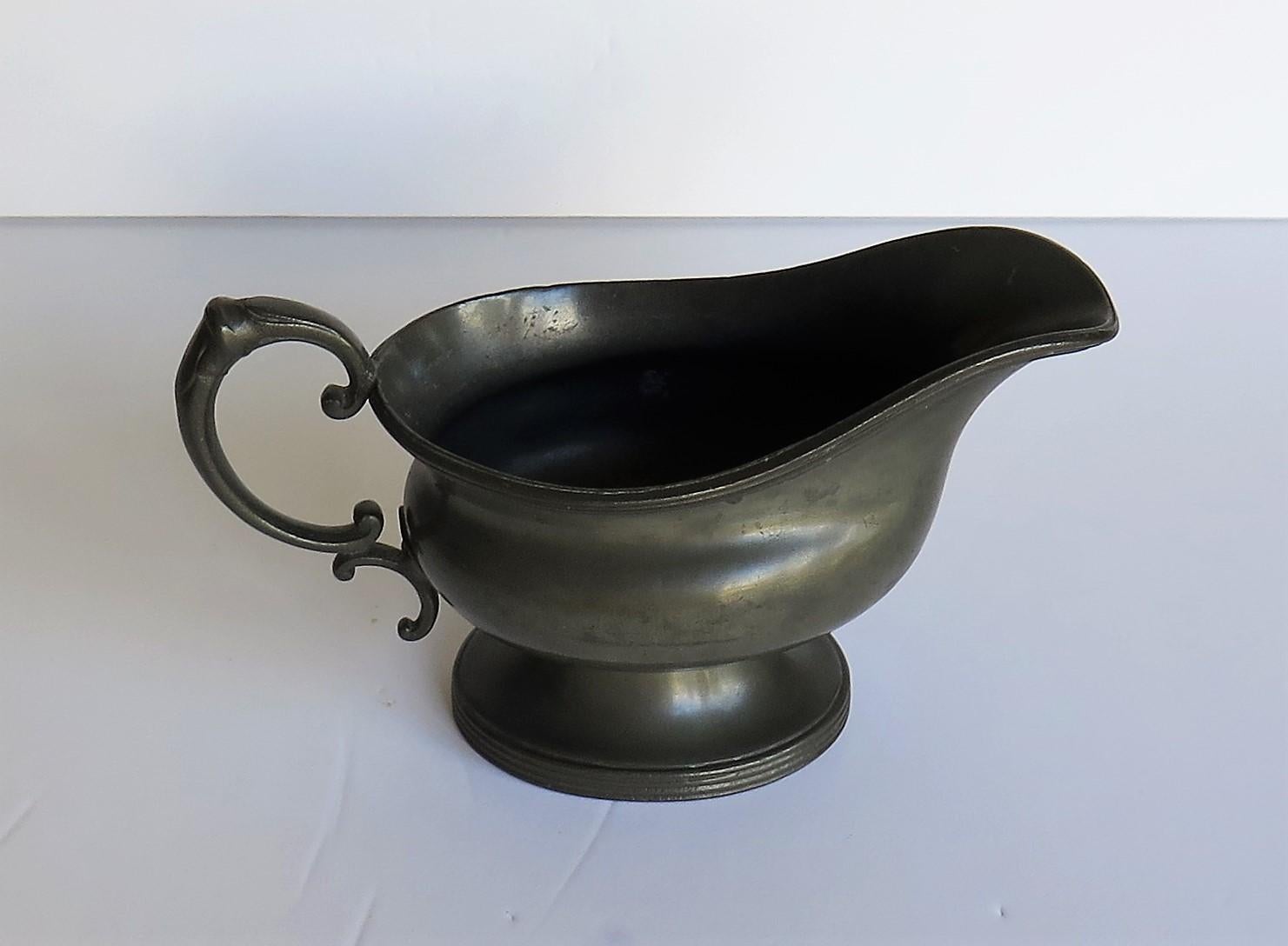 This is a good late 19th century pewter sauce or gravy boat with good reeded detail made by Walker & Hall of Sheffield, England with a full set of stamped marks to the base for the period.

This sauce boat has a lovely rounded body with a single