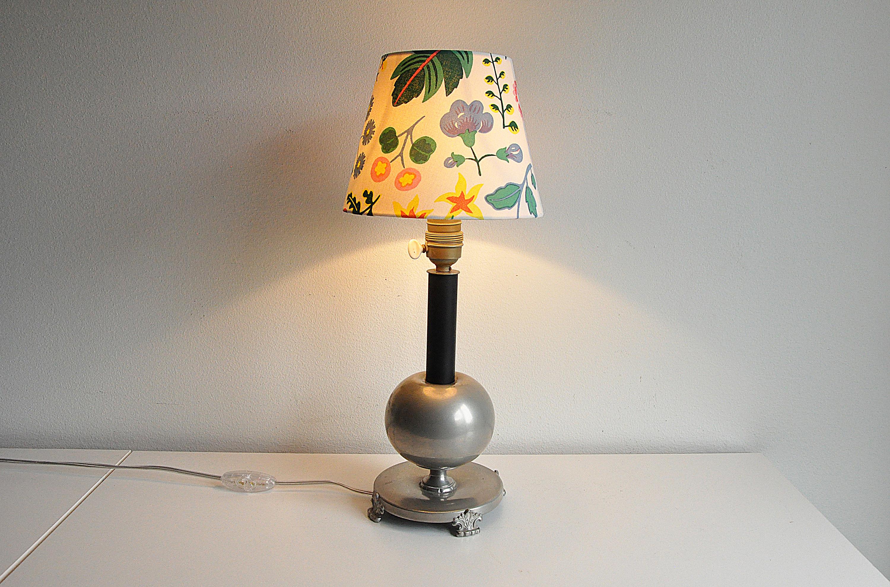 Table lamp in pewter from Nordiska Juvelaktiebolaget, 1935.
Rewired. Lamp shade is not included.
Good vintage condition, wear and patina consistent with age and use. 
Scratches and marks.