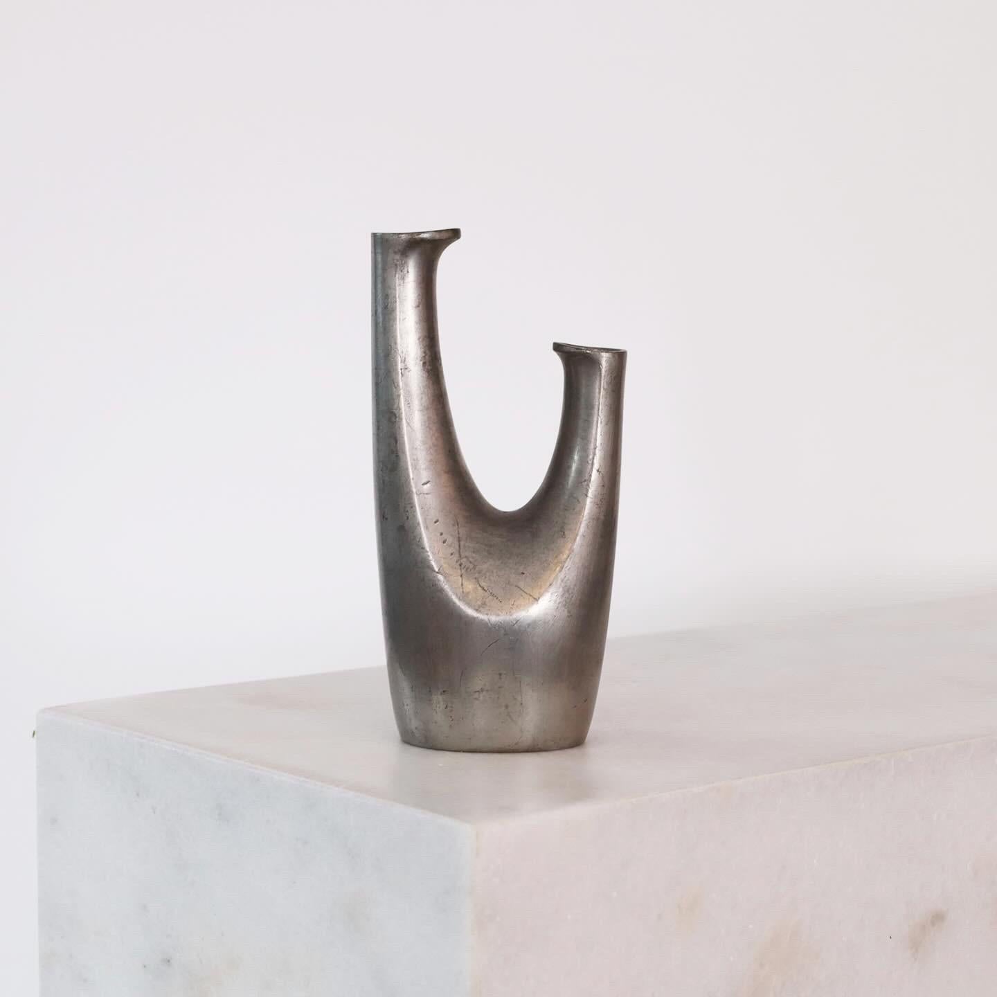 A curvy two-pipe Pewter Vase designed  Ellen Schlanbush for Just Andersen in the 1950s. An elegant piece for a beautiful place.

* A pewter vase with two pipes
* Designer:  Ellen Schlanbusch
* Manufacturer: Just Andersen
* Style: 2705  
* Year: