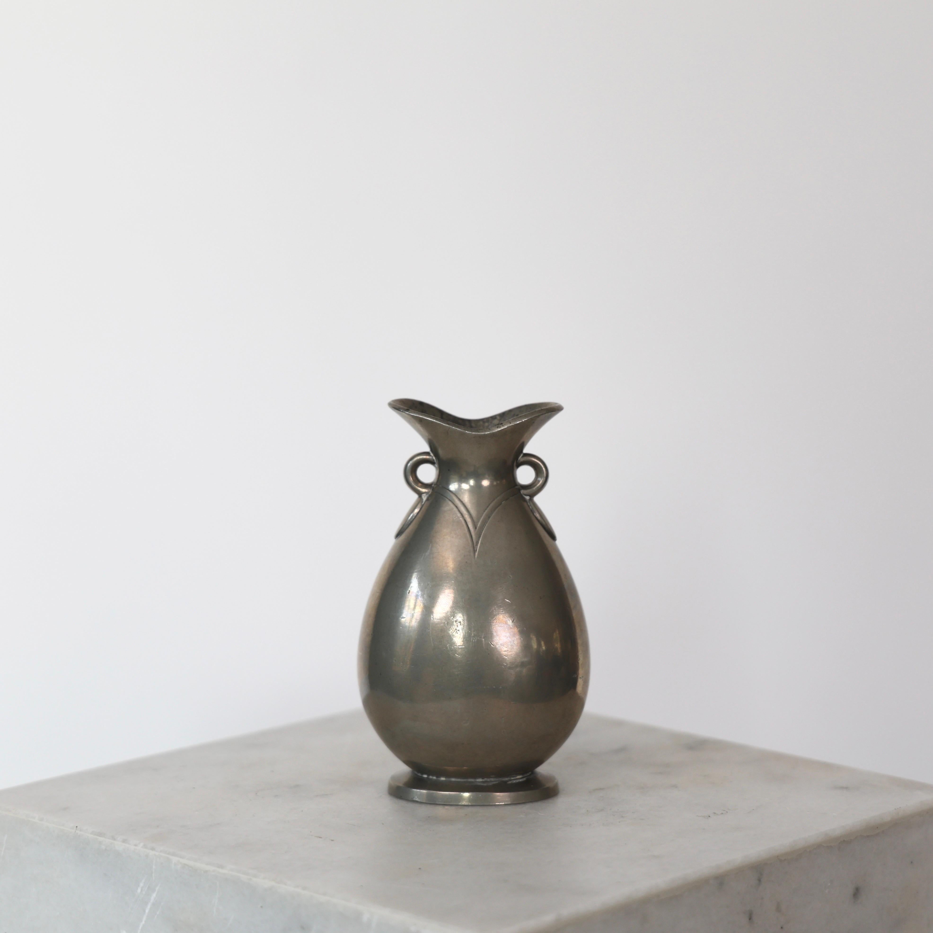 Lovely Pewter Vase designed by Just Andersen in the 1920s. 

* Drop-shaped pewter vase
* Designer: Just Andersen
* Model: 1556 
* Year: 1918-1929
* Condition: Fair vintage condition. Makers engraving intact. Marks and tear, and a bit of limestone on