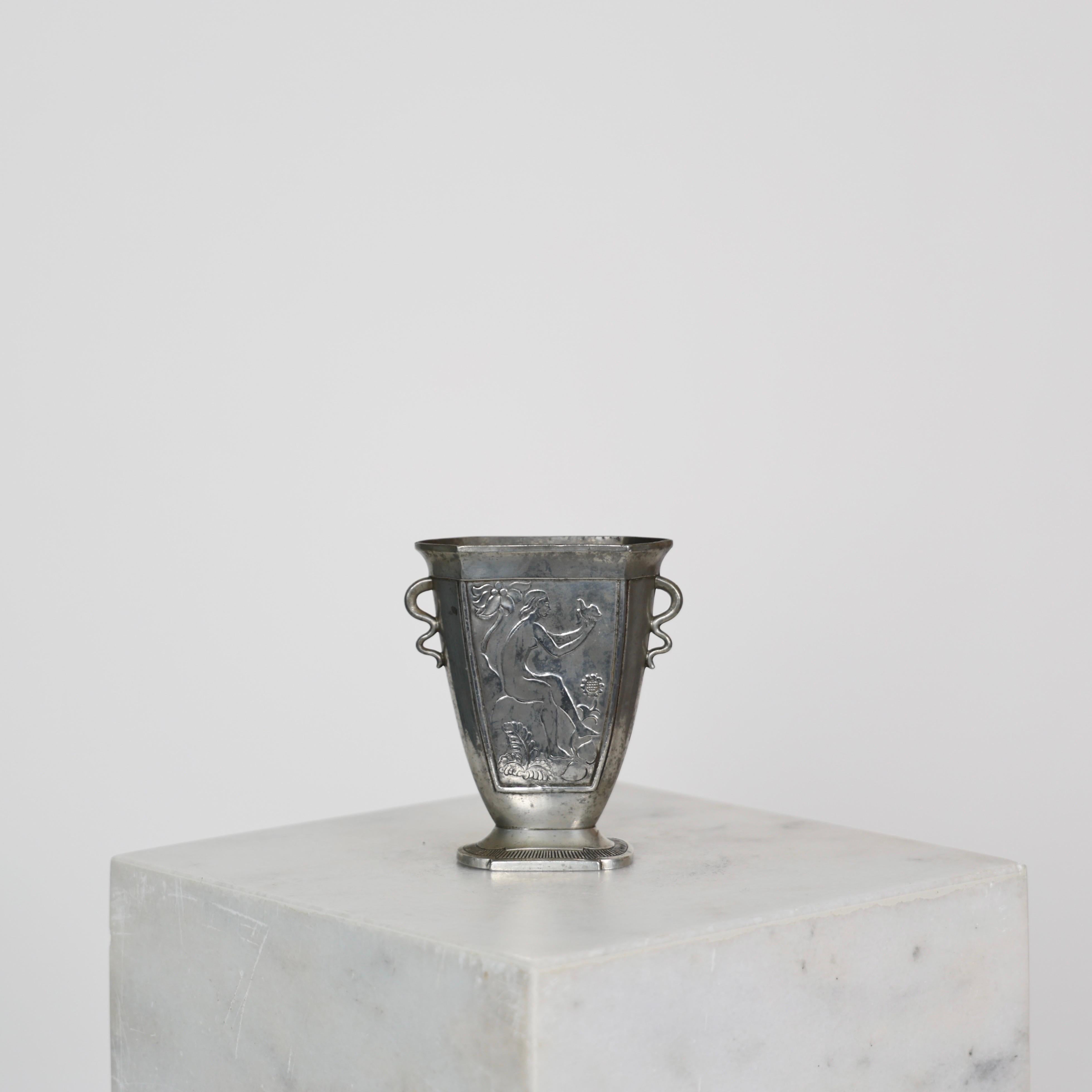 Elegante Vase aus Zinn, entworfen von Just Andersen in den 1920er Jahren.

* Zinnvase mit Ornamenten, die eine Frau mit einer Taube darstellen
* Designer: Just Andersen
* Hersteller: Just Andersen
* Stil: MT 38
* Jahr: 1918-1926
* Zustand: