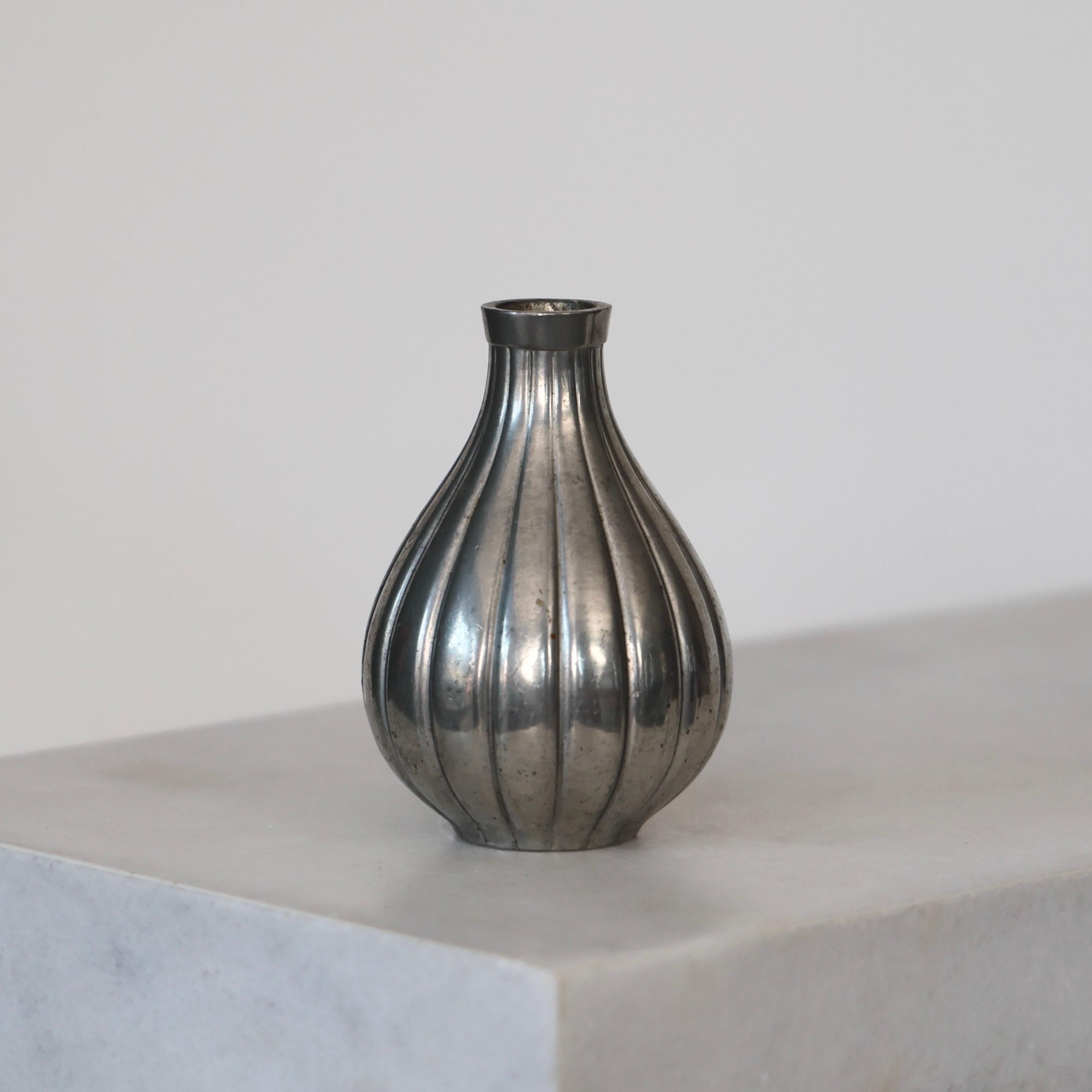 Vaso in peltro realizzato da Just Andersen nel 1952. Un pezzo elegante per un posto bellissimo.

* Vaso in peltro a forma di goccia con linee verticali
* Produttore: Just Andersen
* Stile: 2642
* Anno: 1952
* Condit: Discrete condizioni vintage.
