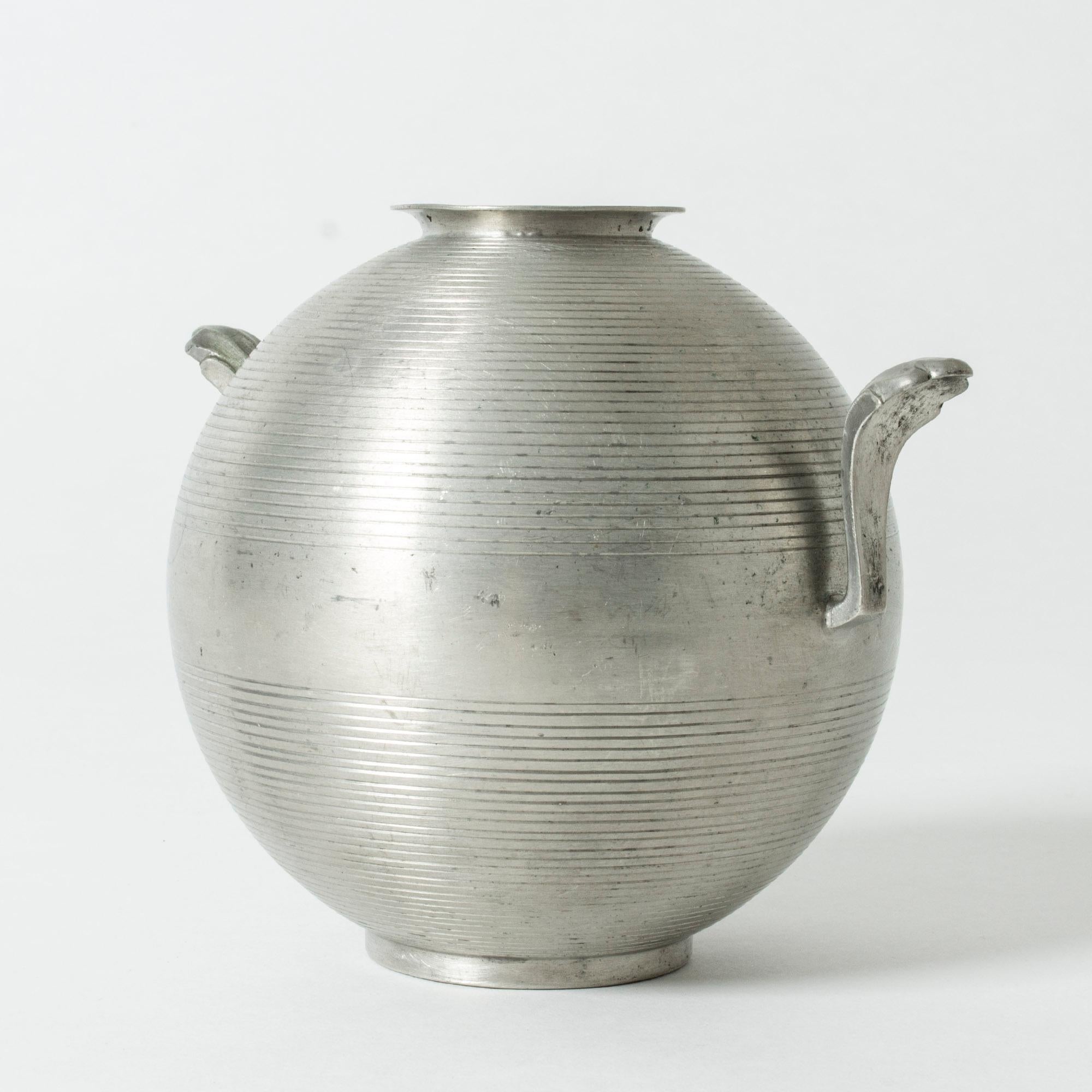 Round pewter vase by Sylvia Stave, with decorative handles on the sides. Smooth design with horizontal stripes. Sober and elegant.
 
  