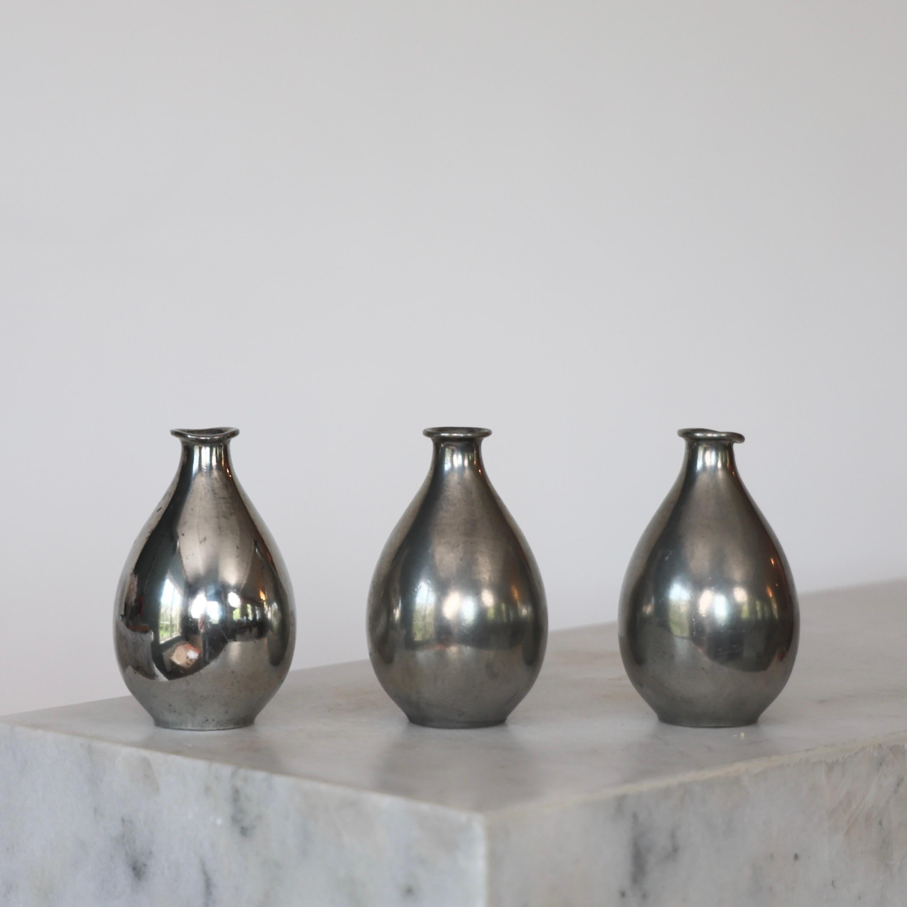 Bottle-shaped Pewter Vases designed by Ellen Schlanbush for Just Andersen in the late 1940s. An elegant trio for a beautiful table.

* Set (3) of small square bottle-shaped pewter vases
* Designer: Ellen Schlanbusch
* Manufacturer: Just Andersen
*