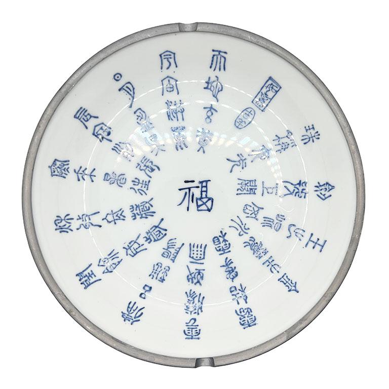 Un grand bol rond vintage en céramique et étain de style chinoiserie. Ce grand bol en céramique est créé à partir d'une céramique d'un blanc éclatant. Le centre est orné de calligraphies chinoises bleues disposées de manière concentrique du centre