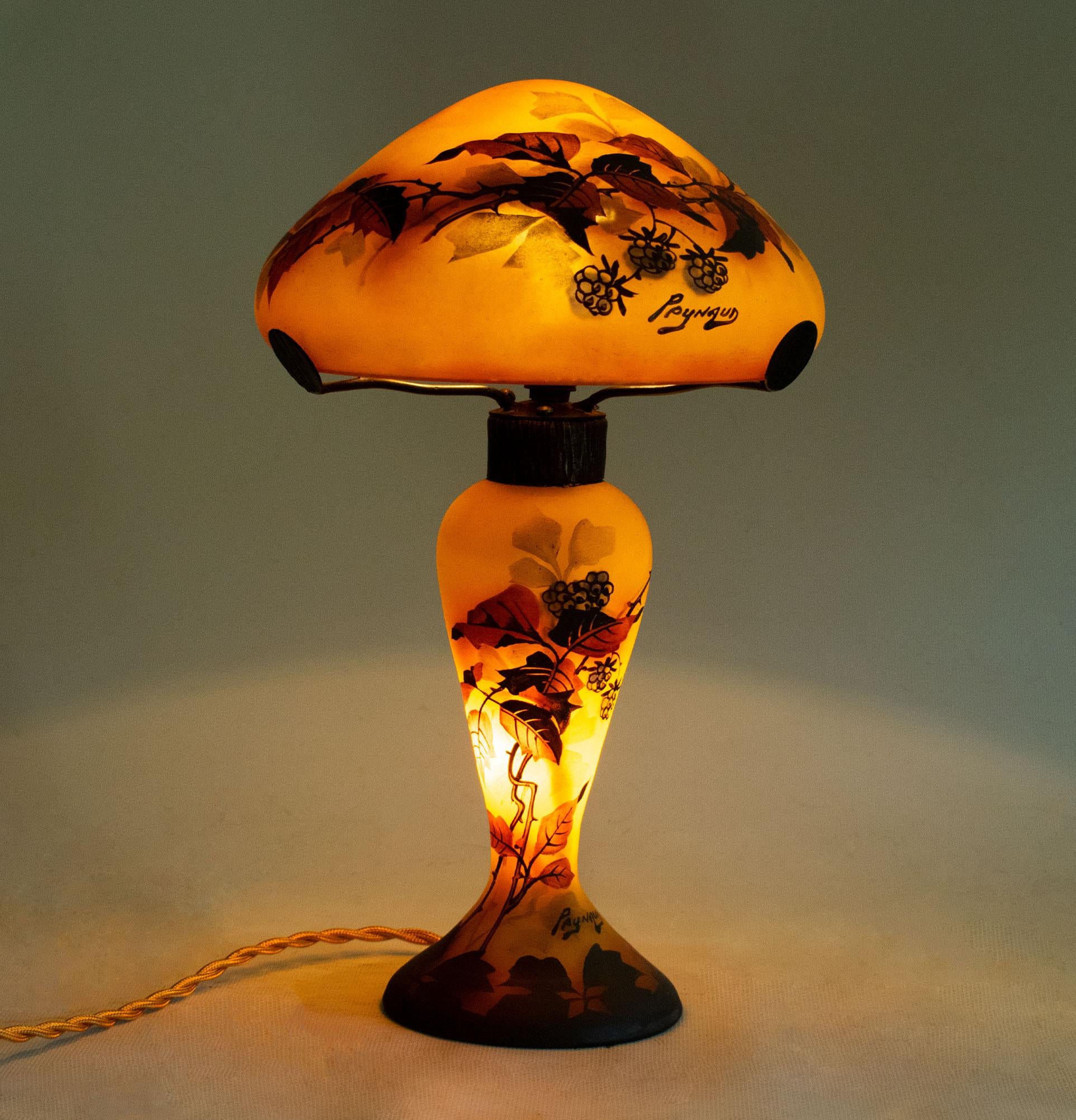 PEYNAUD ESTABLISHMENTS

Art Nouveau table lamp with baluster base with a heat-moulded notch and mushroom lampshade.  Decor of mulberry blossoms in natural polychrome enamels on an orange-yellow background. Produced in the Art Nouveau period, circa