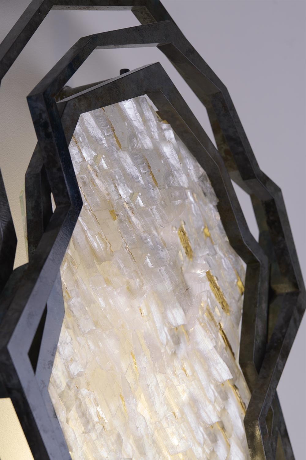 __
A destructured form, with a patina, for the P.Gouthière wall lamp associating
the transparency of the selenite to the reflections of the rock crystal.

__
Création : Antoine DARIULE

Antoine is a metal artist and designer. 
He publishes art