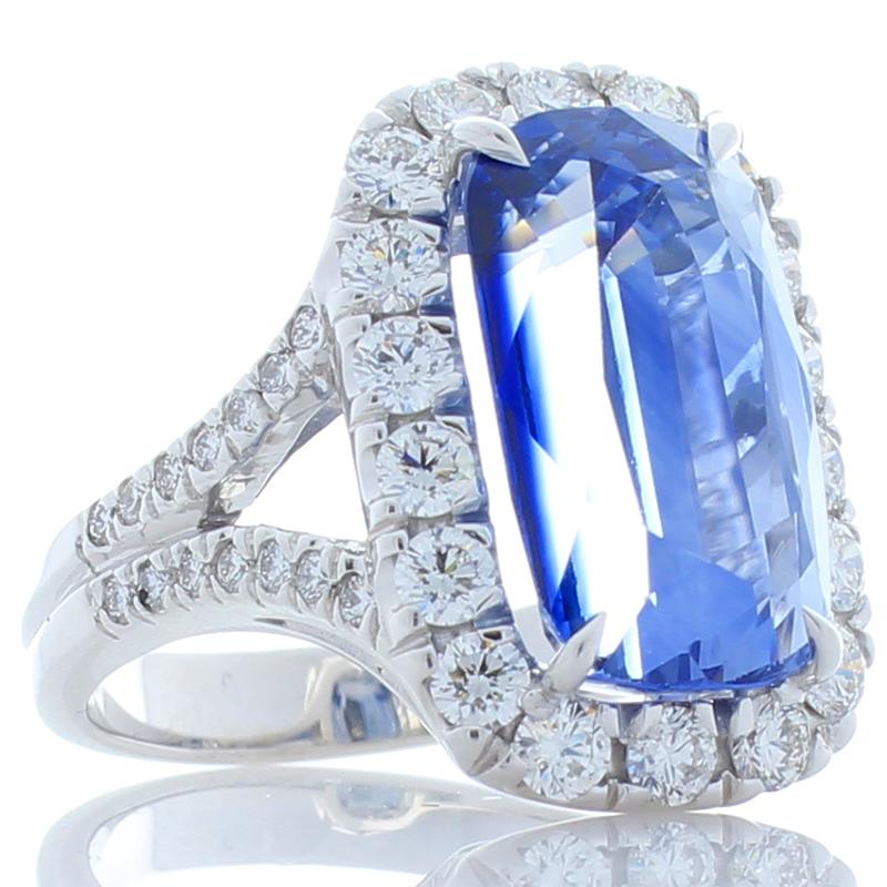 Get lost in the beautiful blue hues of this gorgeous sapphire ring. This is a unique 11.79 carat elongated cushion blue sapphire. It is PGS certified and measures 15.13 x 9.00mm. The gem source is Sri Lanka; its clarity and transparency is