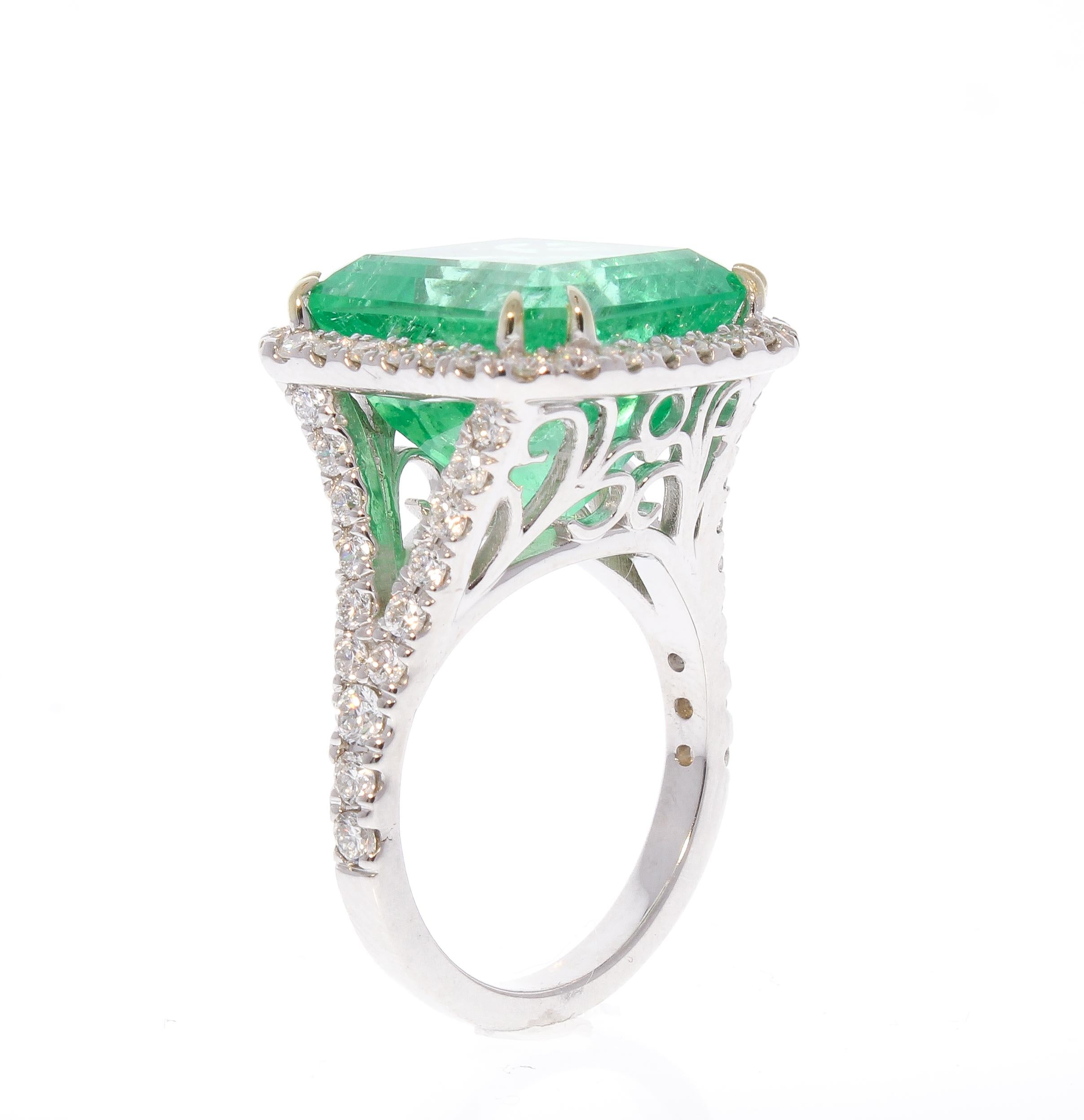 This lavish cocktail ring features a 13.06 carat emerald; the gem source is Colombia, known for the top source for emeralds in the world, the luster, material, and yellowish-green color are superb. Sparkling round brilliant cut diamonds are prong