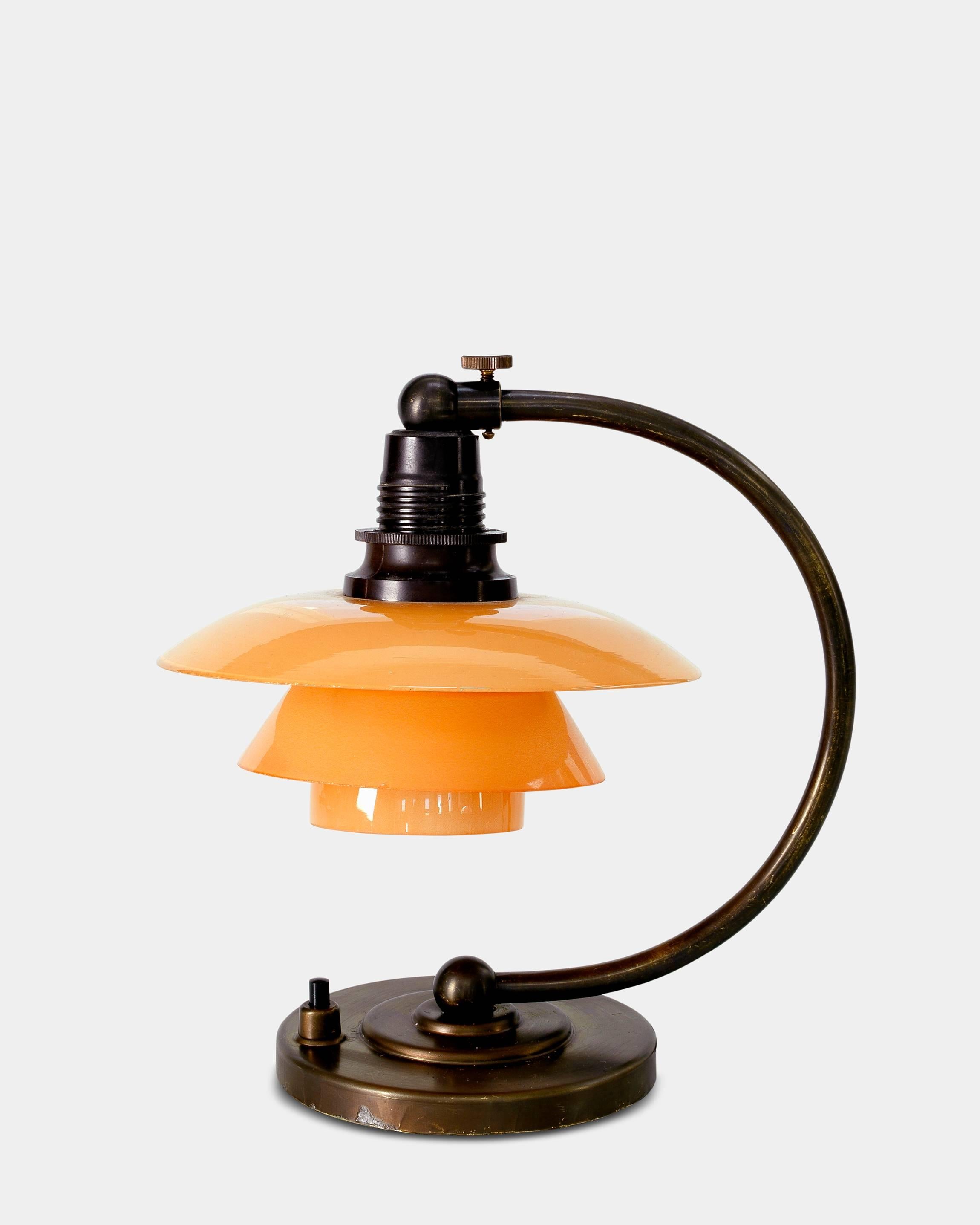 Poul Henningsen (1894-1967) 
1/1 PH table lamp, with browned brass stand, socket in bakelite and with a set of rare rose colored glass shades. Produced by Louis Poulsen in 1936. Stamped PATENTED and thereby a unique vintage piece by Poul Henningsen.