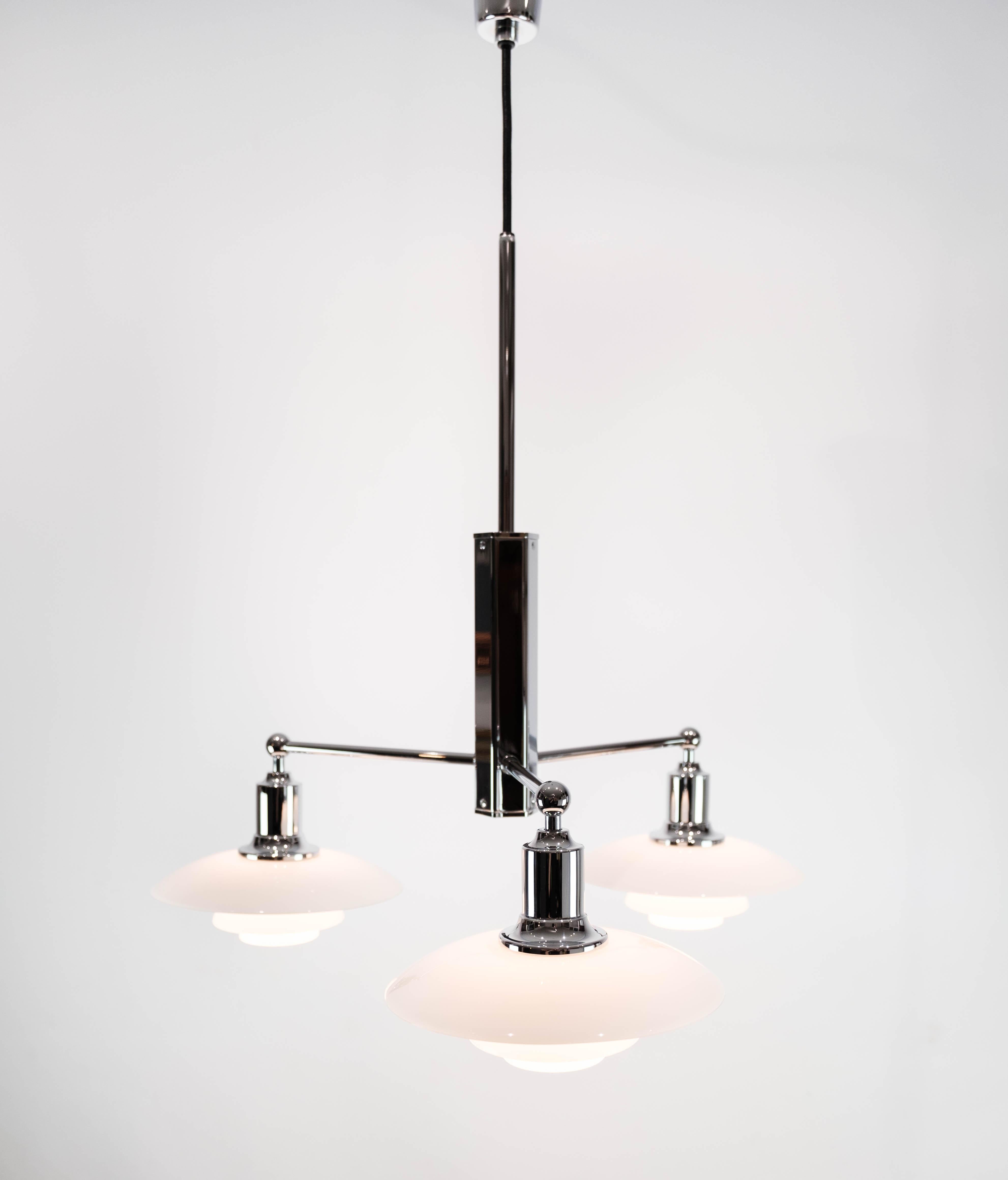 This PH 2/1 stem fitting, designed by the renowned Poul Henningsen and manufactured by Louis Poulsen in the 1980s, epitomizes the iconic Danish lighting design of the era. Crafted from chrome, its sleek and minimalist silhouette exudes a sense of