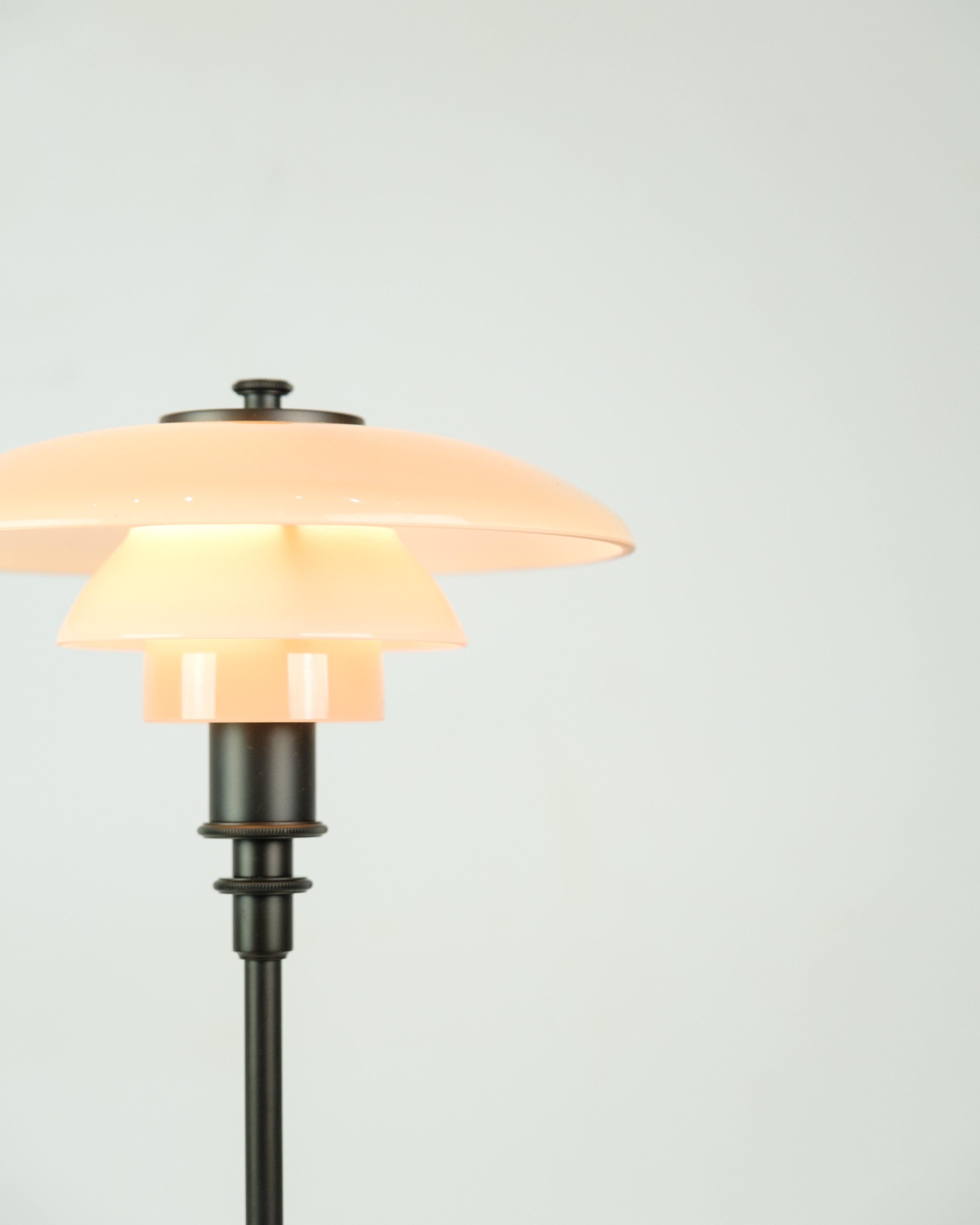 La lampe de table exclusive PH 2/1 est une édition limitée de Louis Poulsen, conçue par Poul Henningsen. La lampe est équipée d'un abat-jour en verre soufflé à la bouche à quatre couches, d'une couleur unique Dusty Terracotta, qui crée une