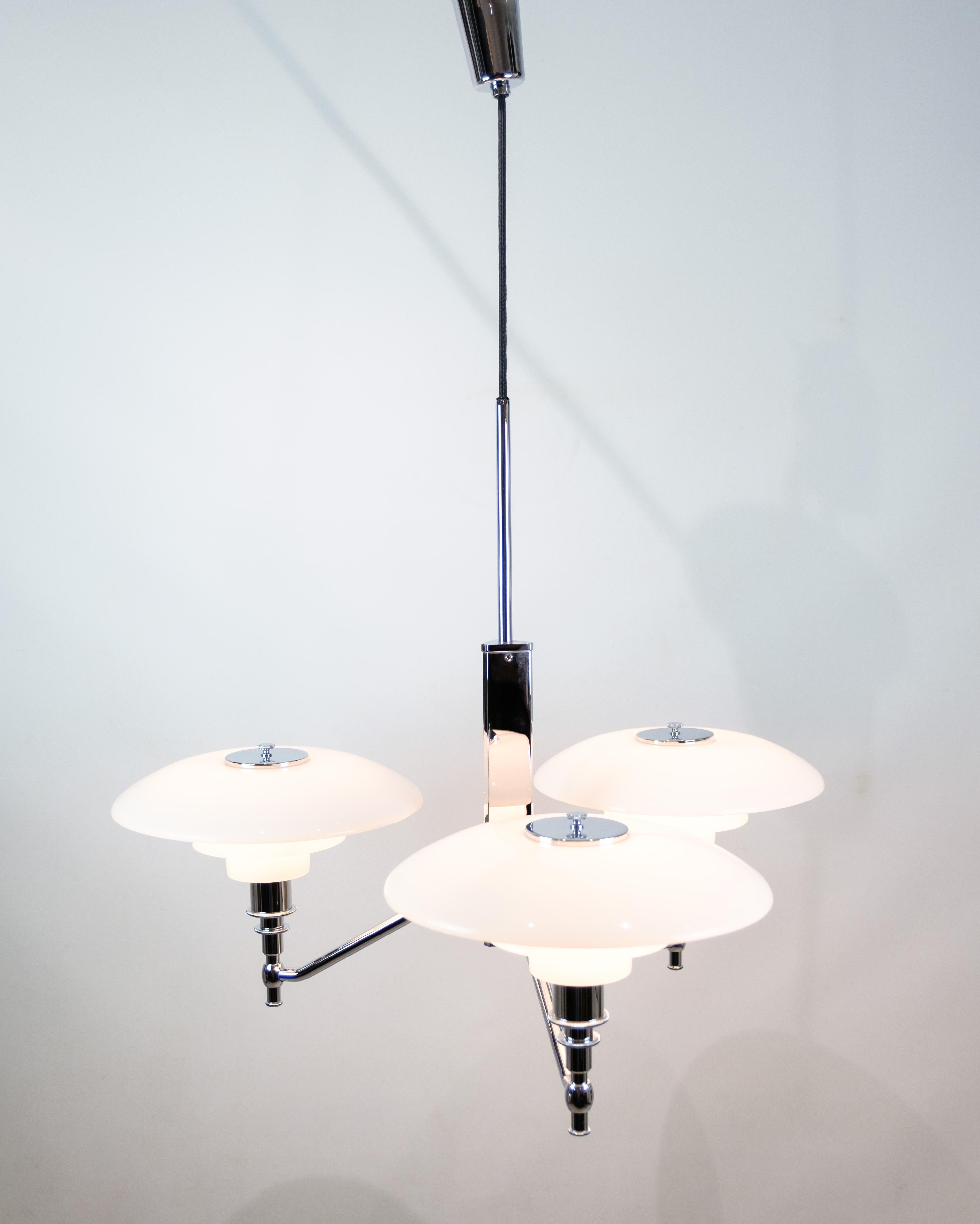 Die PH 3/2 Academy crown, die von Poul Henningsen 1925-1926 entworfen und im Jahr 2000 auf den Markt gebracht wurde, ist ein Zeugnis für die zeitlose Eleganz und die innovativen Designprinzipien von Henningsens Arbeit. Diese von Louis Poulsen