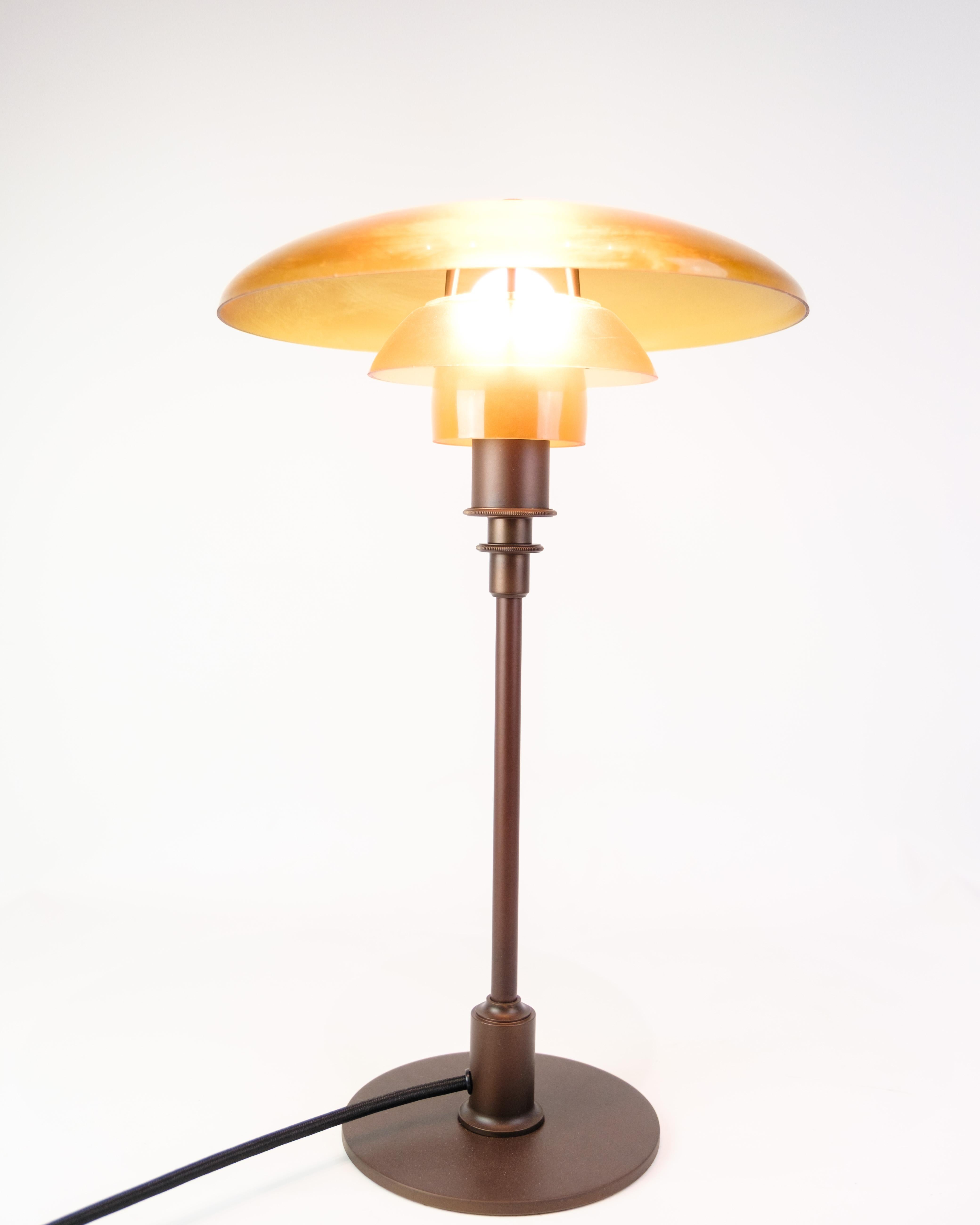 Lampe de table PH 3/2 conçue par Poul Henningsen et produite par Louis Poulsen dans les années 1930. Ce modèle classique est réalisé avec un système à trois abat-jours en verre soufflé à la bouche, d'un ton ambré chaud, qui procure une lumière douce