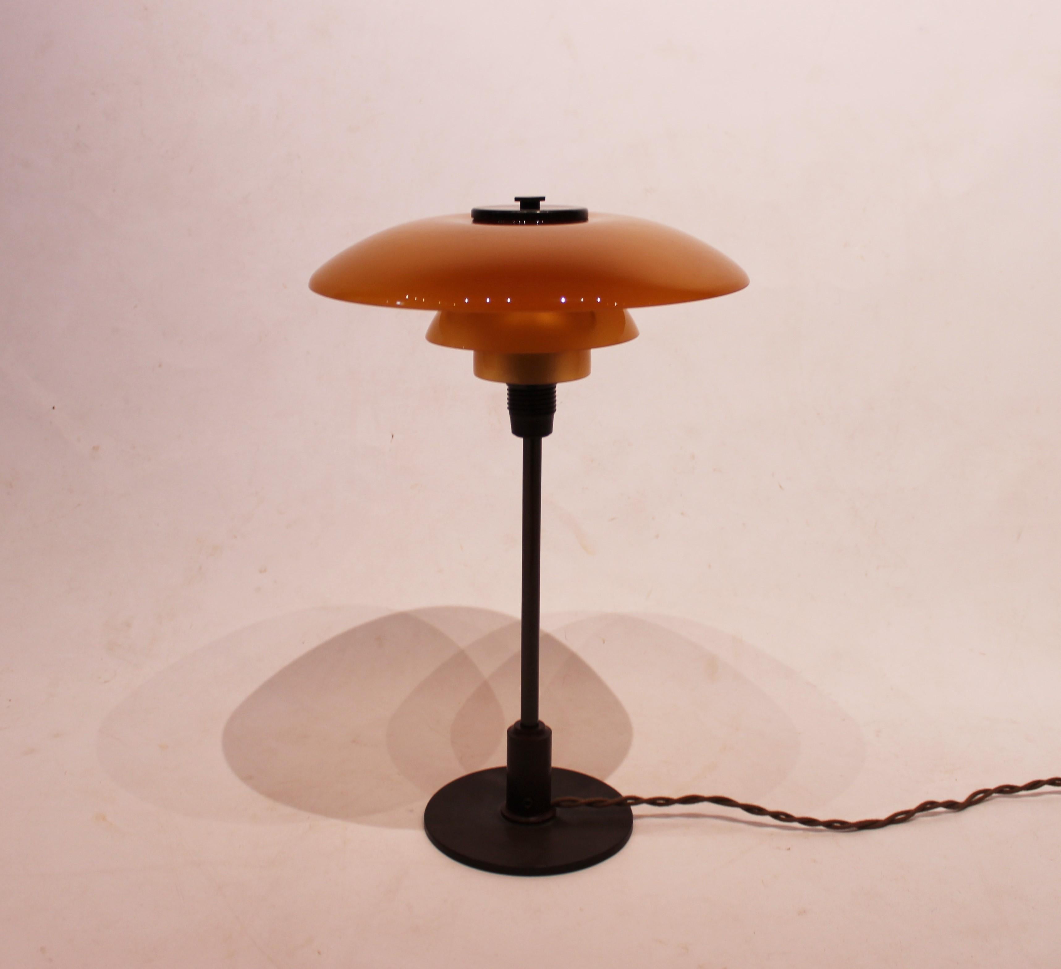 PH 3/2 table lamp with amber colored shades, frame of burnished brass and bakelite socket designed by Poul Henningsen and manufactured by Louis Poulsen in the 1930s. The lamp is in great vintage condition.