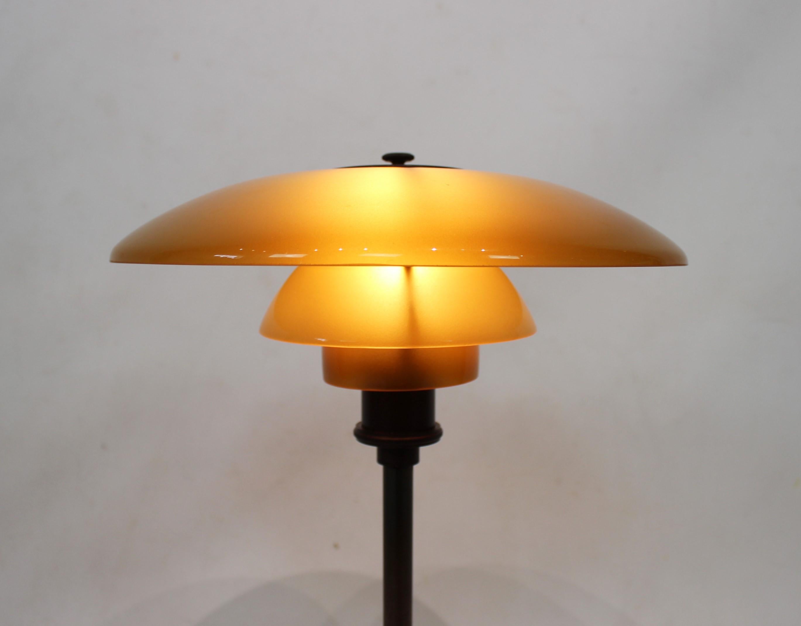 PH 3/2 tablelamp with shades of amber colored glass and frame of burnished brass, designed by Poul Henningsen and manufactured by Louis Poulsen in the beginning of the 1930s. The lamp is in great vintage condition.
Measures: Height 47 cm and