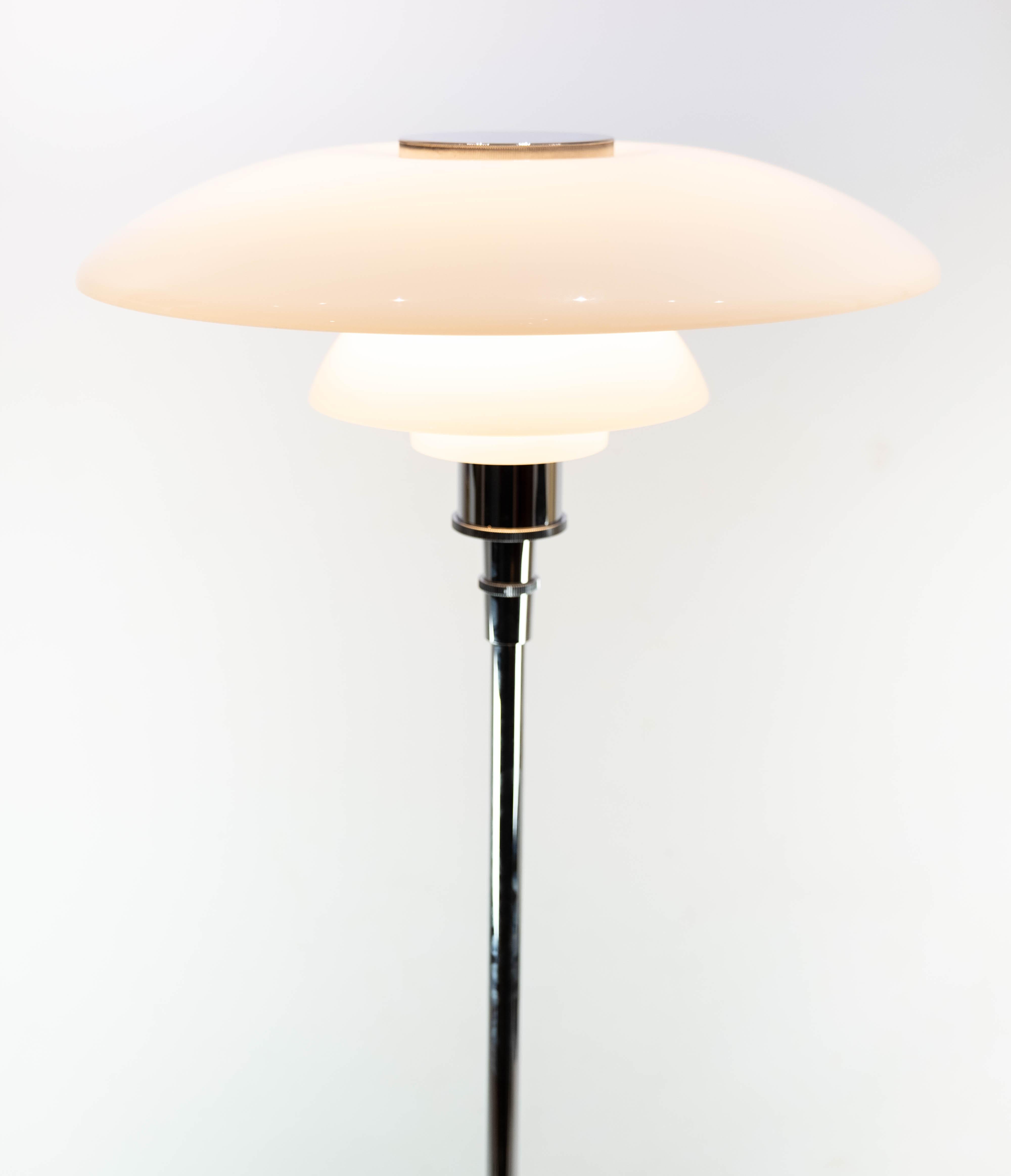 The PH 4 1/2-3 1/2 floor lamp, characterized by its elegant chrome frame and opaline glass shades, is a quintessential example of Scandinavian Modern design. Created by the renowned Danish designer Poul Henningsen, this lamp showcases his signature