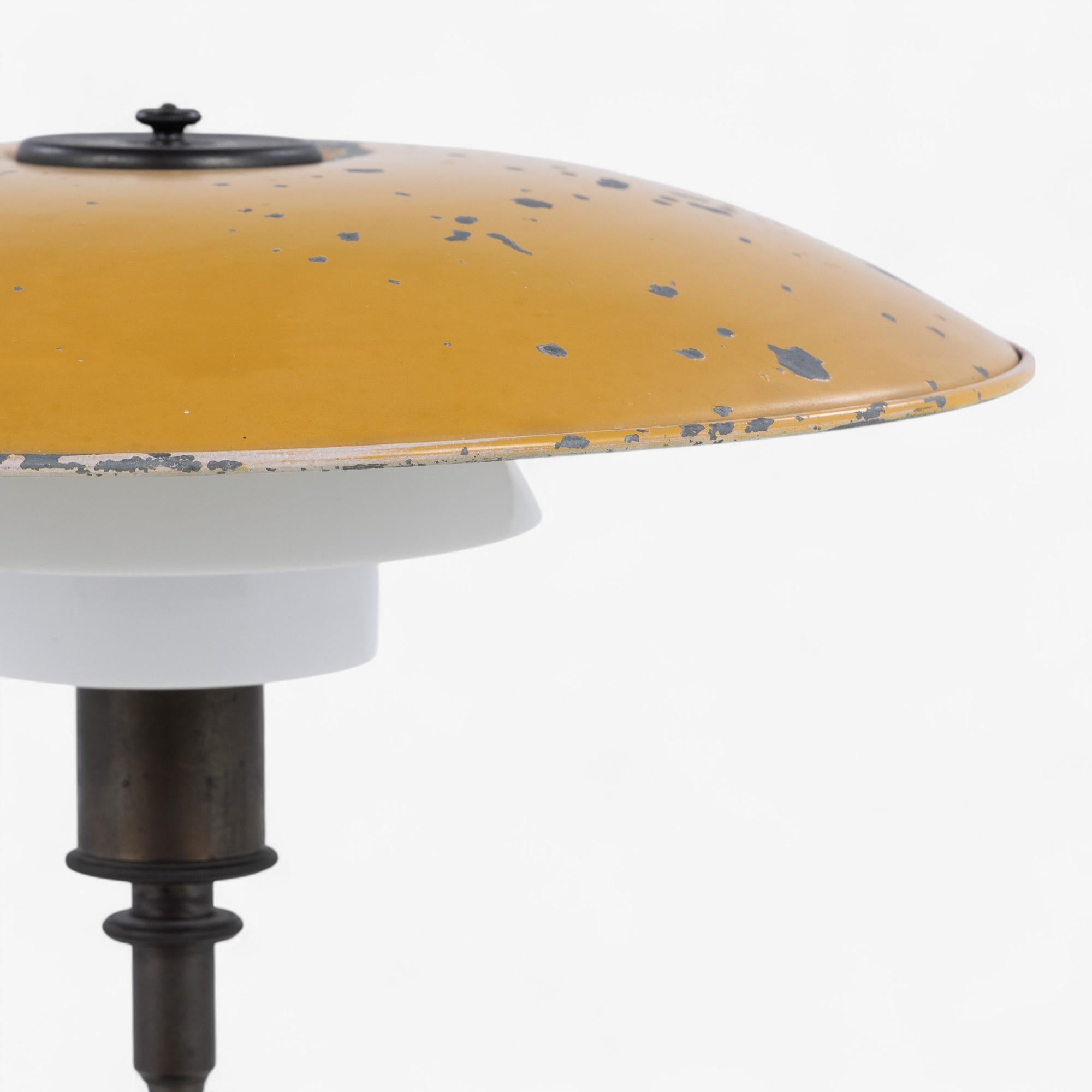 PH 4,5/3 - Table lamp in burnished brass with top shade in yellow lacquered zinc shade and middle and bottom shade in white opal glass. Stamped ‘PATENTED’. From c. 1930.