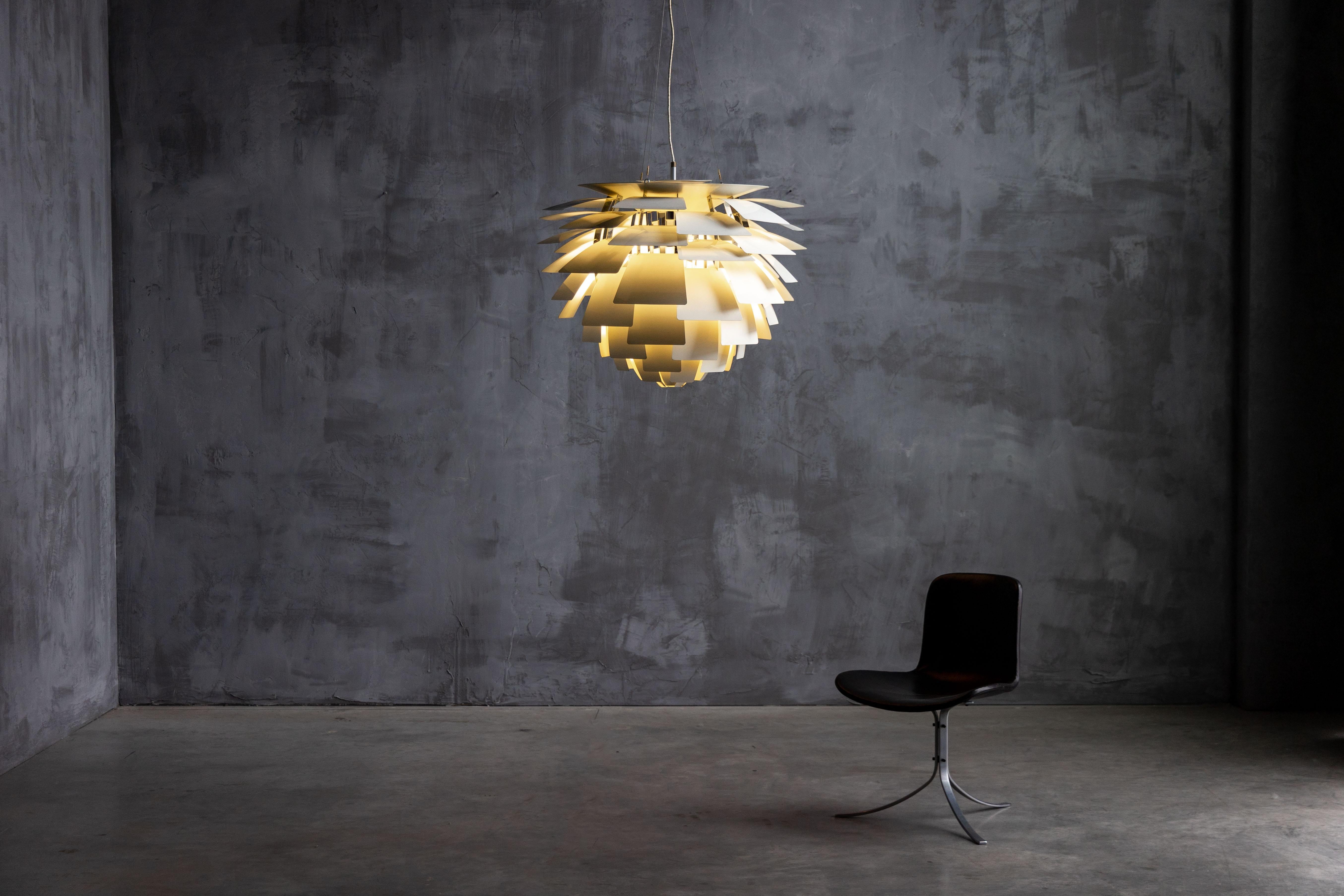 The iconic Poul Henningsen Artichoke lamp, a masterpiece of Danish design from 1957. Featuring 72 hand-assembled, enameled aluminum leaves, this lamp creates a stunning visual effect by dispersing light evenly, eliminating glare and casting a warm,