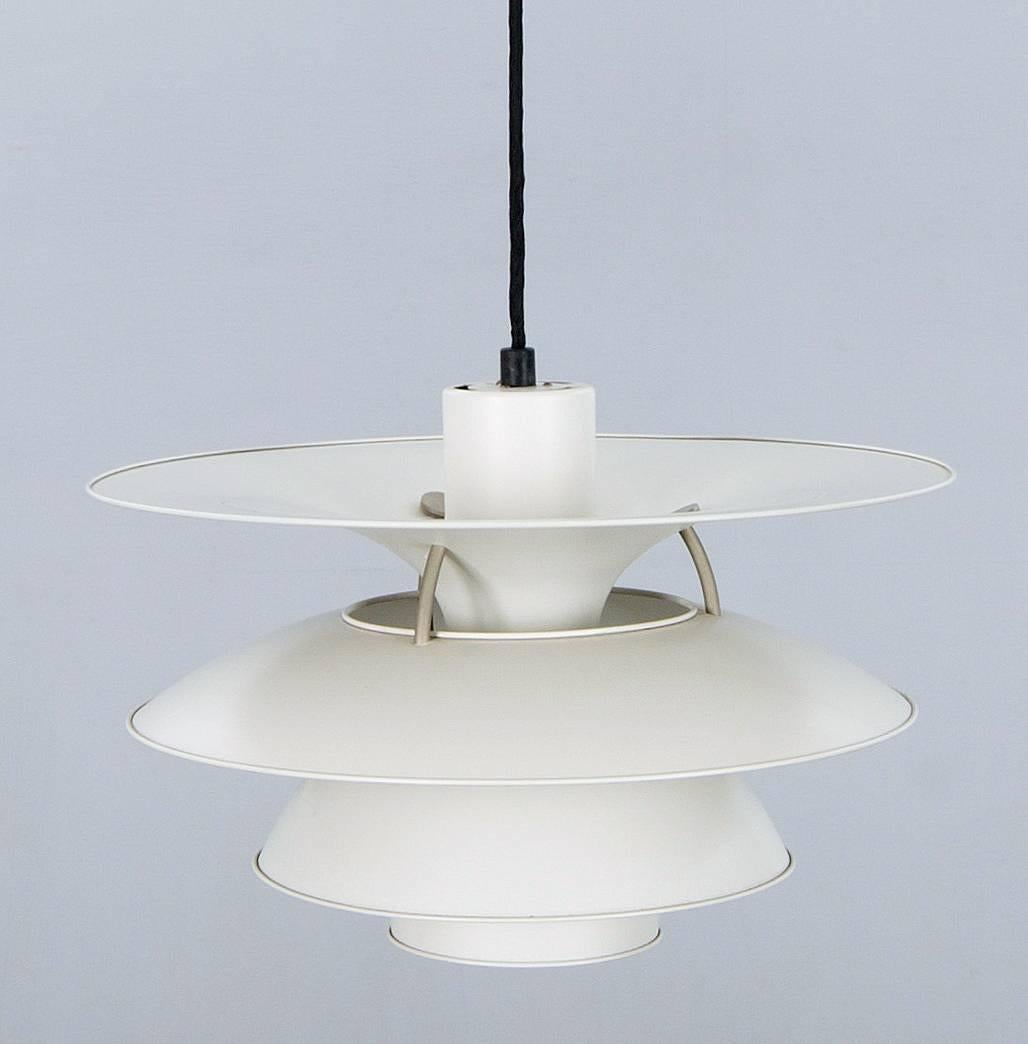 Wonderful Poul Henningsen large Charlottenborg pendant, PH 5-4 1/2 produced by Louis Poulsen. This is the Ø 45 cm version with four shades, off-white lacquered metal ad one blue/purple shade. The lamp is fitted for both US and European use.

  
