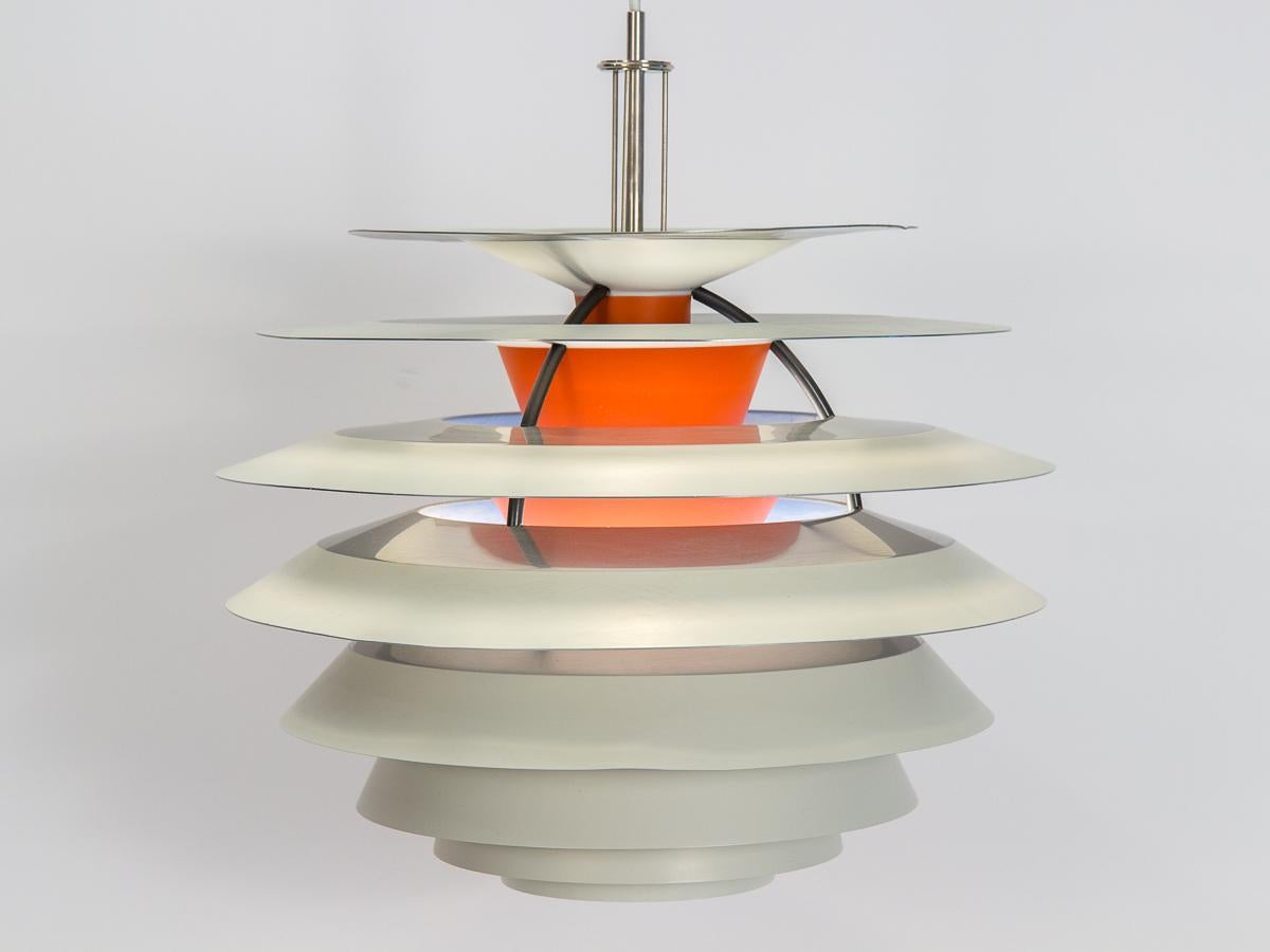 Plafoniera originale Kontrast PH, disegnata da Poul Henningsen per Louis Poulsen. Dieci paralumi in acciaio smaltato scendono a cascata verso il basso, perfettamente posizionati per fornire un'illuminazione brillante senza abbagliare. L'interno è di