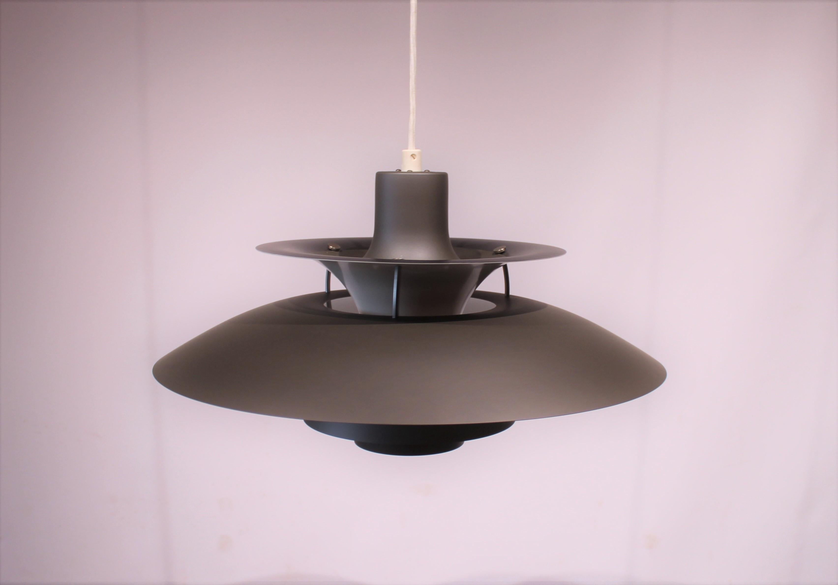 PH5 pendant designed by Poul Henningsen in 1958 and manufactured by Louis Poulsen. The pendant has dark grey lacquered metal shades.