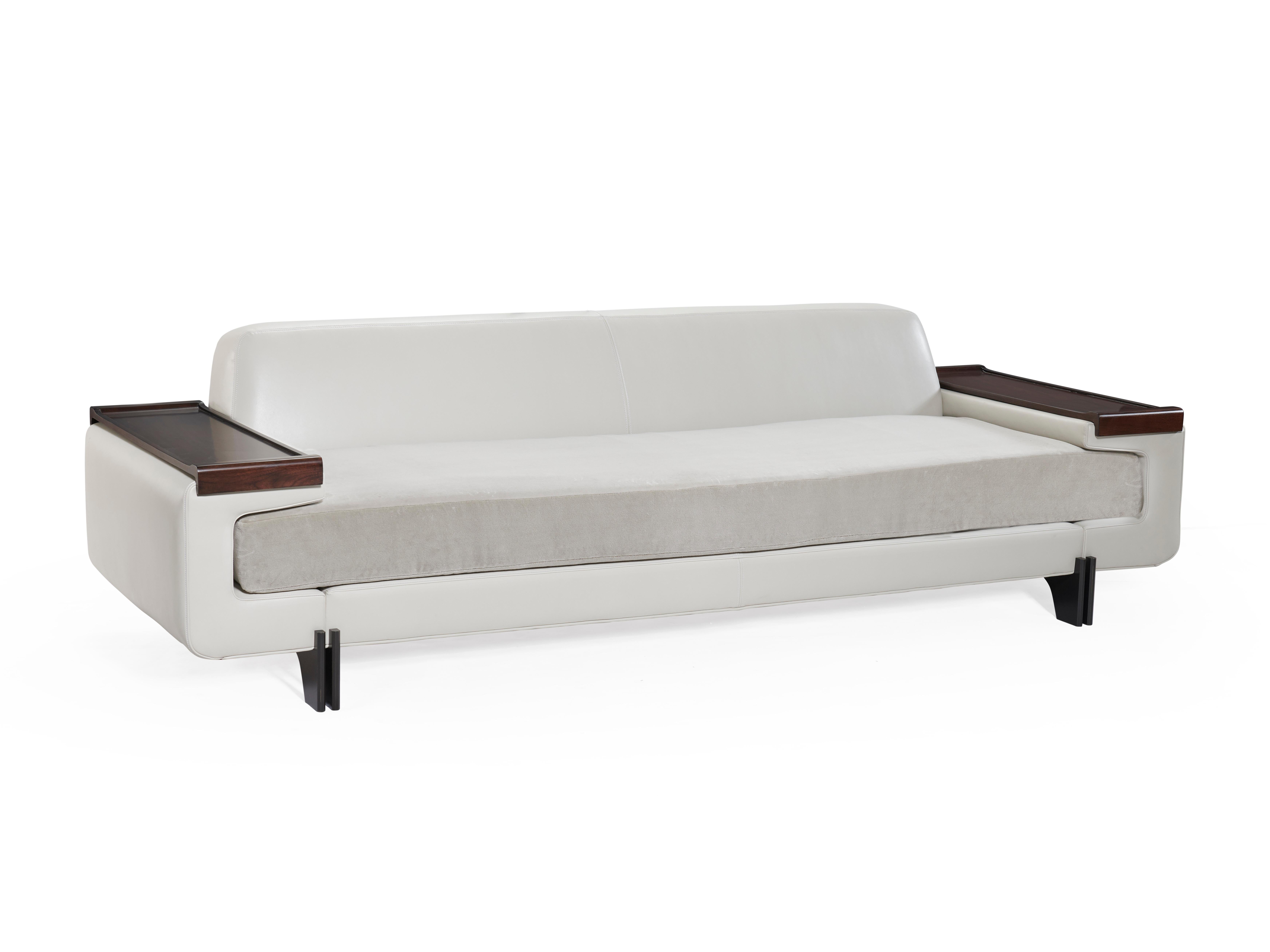 Phalanx loveseat exudes a grounded yet sensual sensibility, its seat is tenderly clasped by a fully upholstered frame which is elevated by patinated legs. Removable wooden trays nest on each arm making this design both sophisticated and practical.