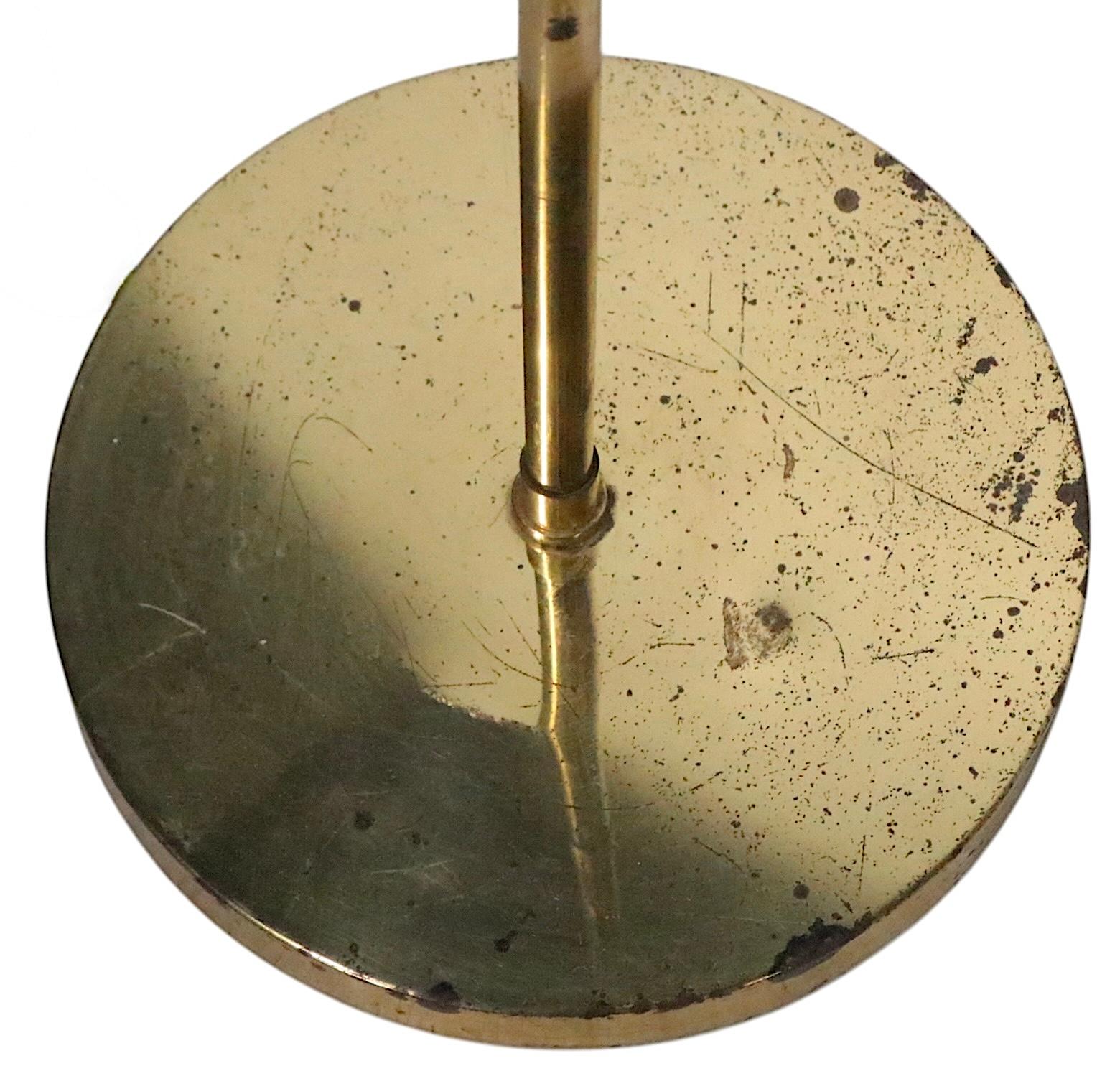 Lampadaire vintage ajustable en laiton de style pharmacie, ayant un poteau central extensible, avec un abat-jour à hotte cylindrique inclinable.
Nous avons trois lampes assorties, toutes ont été recâblées professionnellement et sont en bon état de