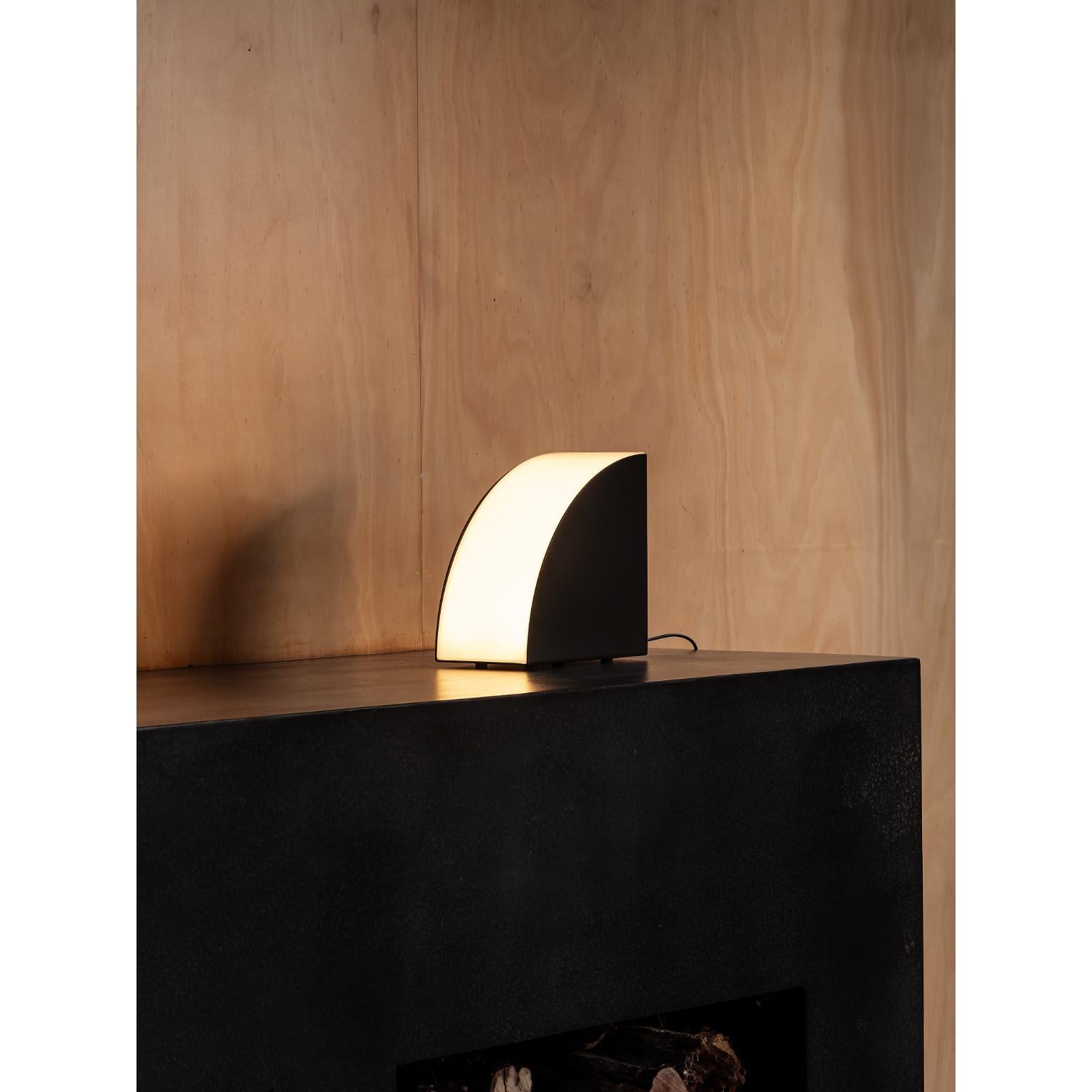 Phase Table Light by Resident
Dimensions: W 20.8 x D 11.5 x H 21 cm
Materials: Powdercoated Aluminium, Acrylic.
Weight: 7 Kg.

About: 
Founded by Simon James & Scott Bridgens in 2011, Resident is the home of enduring design pieces created for the