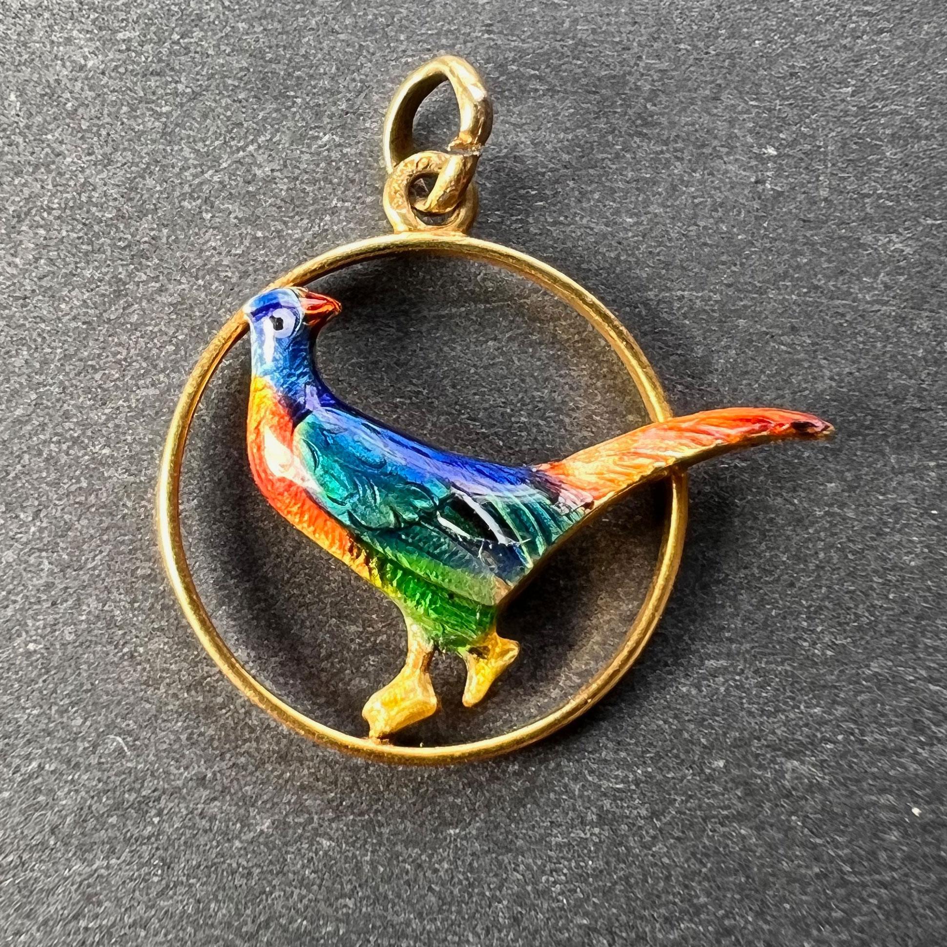 A 14 karat (14K) yellow gold charm pendant designed as a gold circle containing an enamel pheasant. Stamped 585 for 14 karat gold.

Dimensions: 1.8 x 1.9 x 0.35 cm (not including jump ring)
Weight: 0.85 grams 
(Chain not included)
