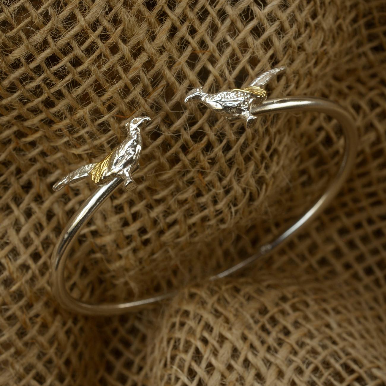 A stunning, unusual Pheasant bangle in 18ct Gold on Solid Sterling Silver.

This robust yet feminine bangle will delight the discerning lady with a penchant for Nature. The Sterling Silver underside is solid and has a natural spring.

This design