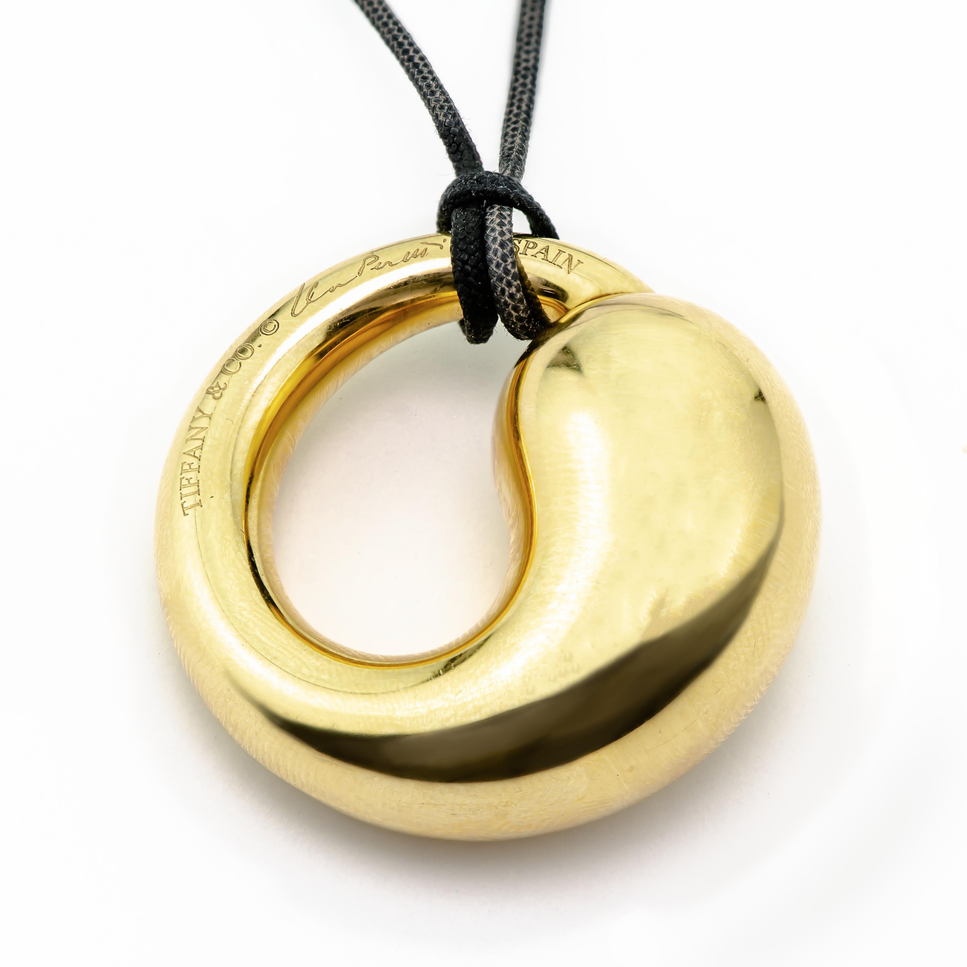 Exquisite Tiffany & Co. Elsa Peretti Large Size Eternal Circle rendered in 18K yellow gold on black cord.  Excellent condition.  All hallmarked and signed.  Pendant in 18k gold. On a 30