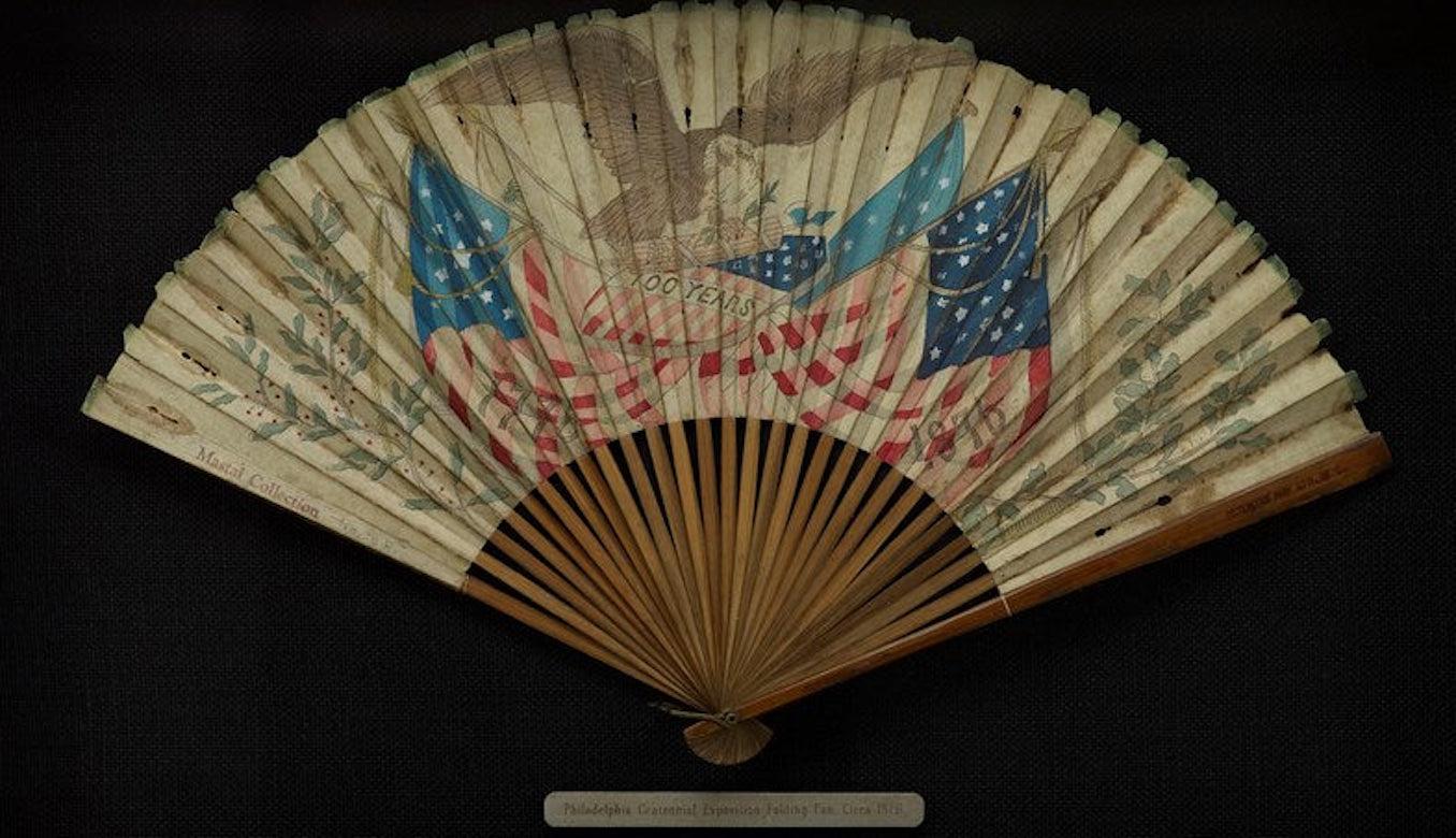 This is a patriotic Centennial fan, designed for and used during the Philadelphia Centennial Exposition of 1876. The Centennial Exhibition was the first World's Fair held in the United States. The celebratory paper fan is printed with crossed