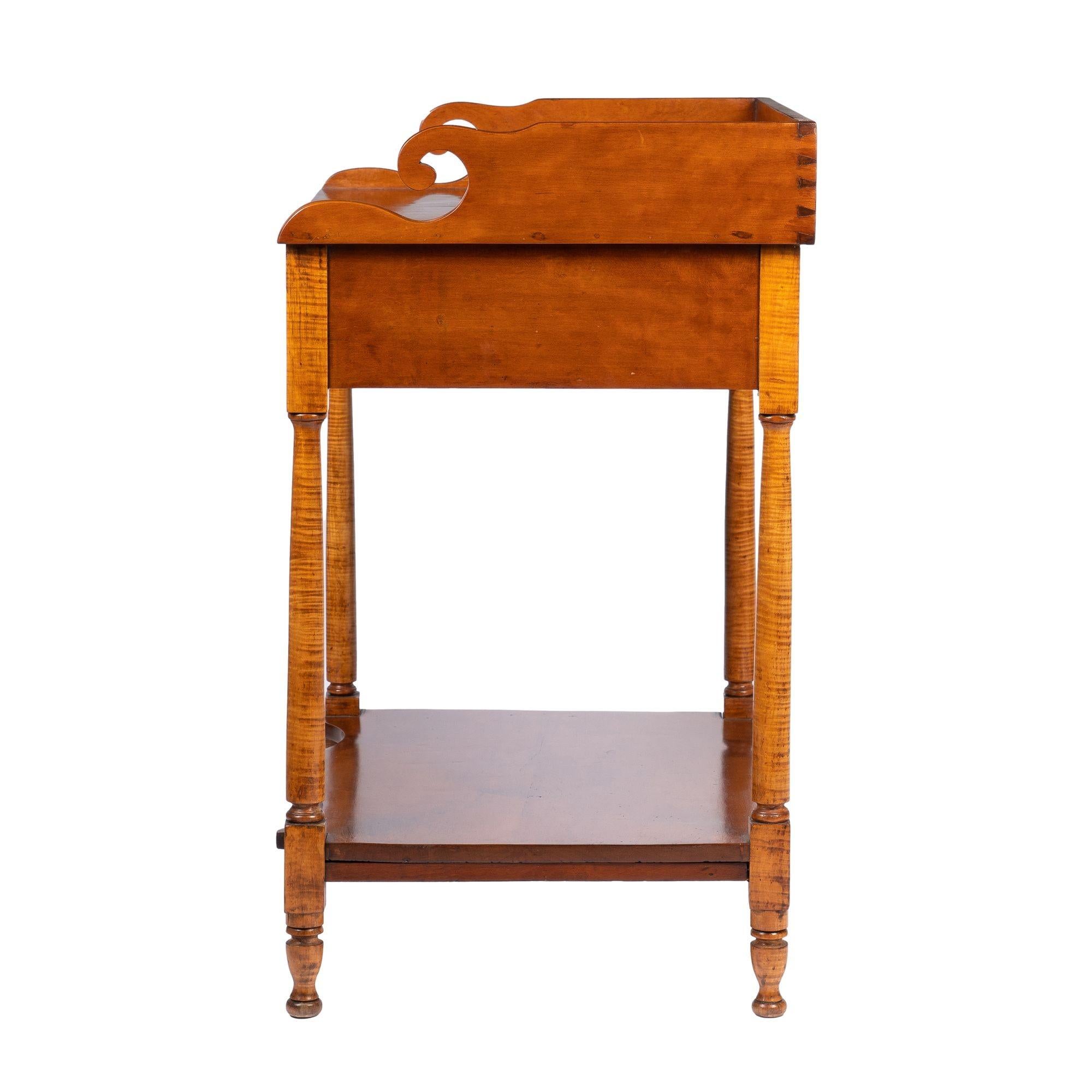 Rectangular cherry wood dressing stand with a scroll terminal splash. The splash rests on a bees wing figured cherry wood apron, which is supported by four curly maple dies and finely turned legs. The cherry wood shelf stretcher has a cupid's bow