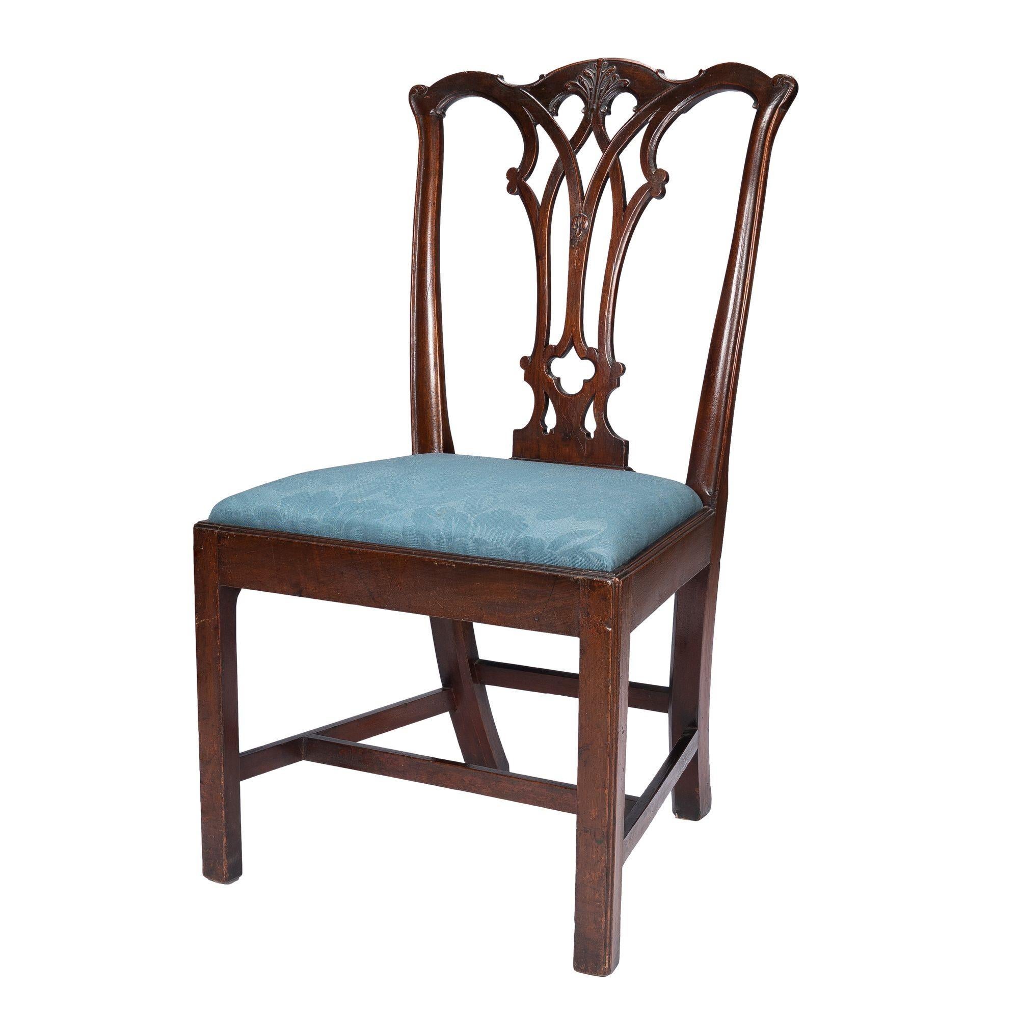 Philadelphia Chippendale mahogany slip seat side chair by Thomas Tuft. The chair crest rail and back splat are carved with rococo detail, and the chair rests on square ended out legs joined by an “H” stretcher. The slip seat has been upholstered in