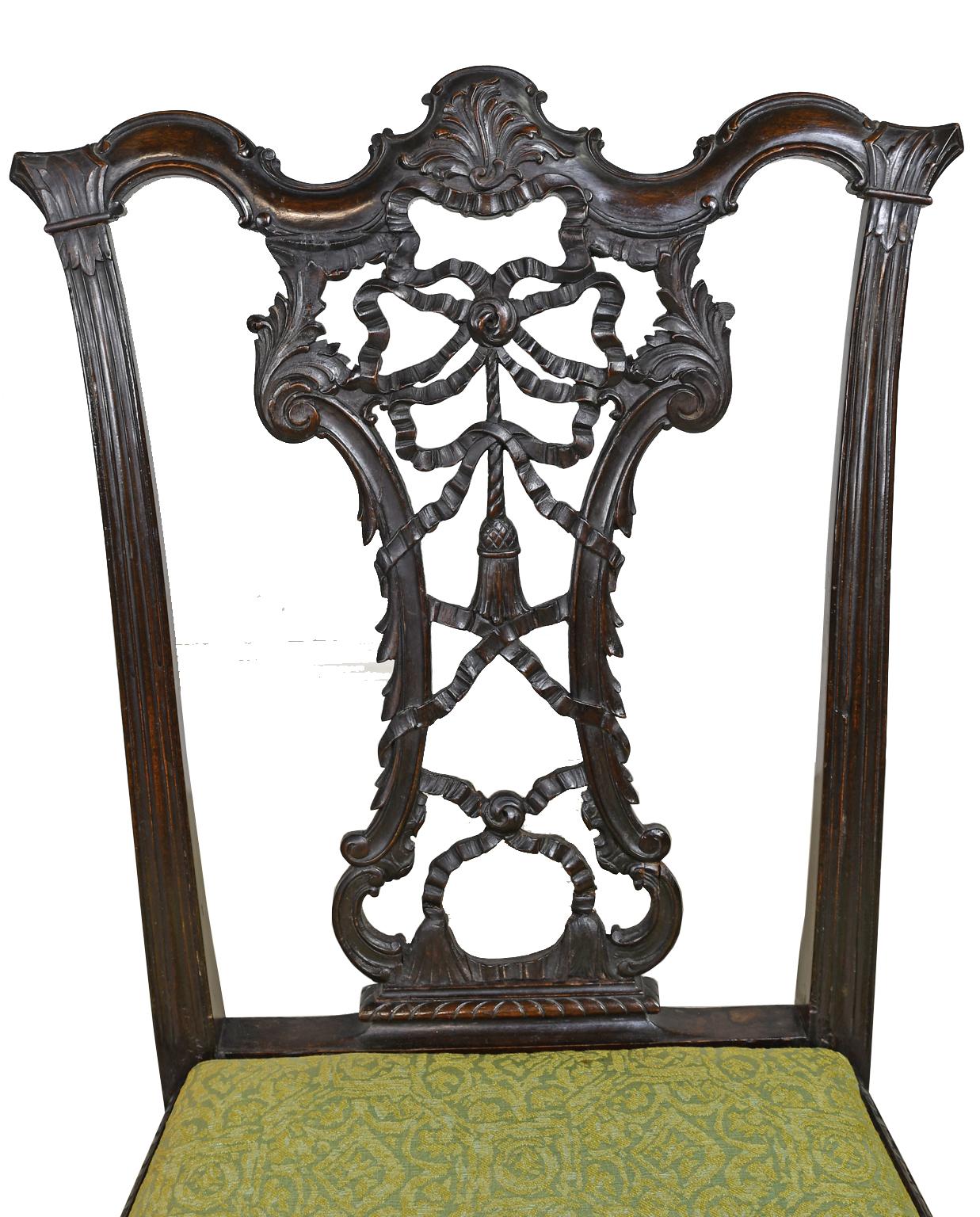 A very beautiful Rococo-Revival, Chippendale style chair in mahogany with ribbon-back carving. Exquisitely carved and articulated ribbon back framed by acanthus carved foliates. Chair knees and talloned claw feet are well-articulated. Slip seat is