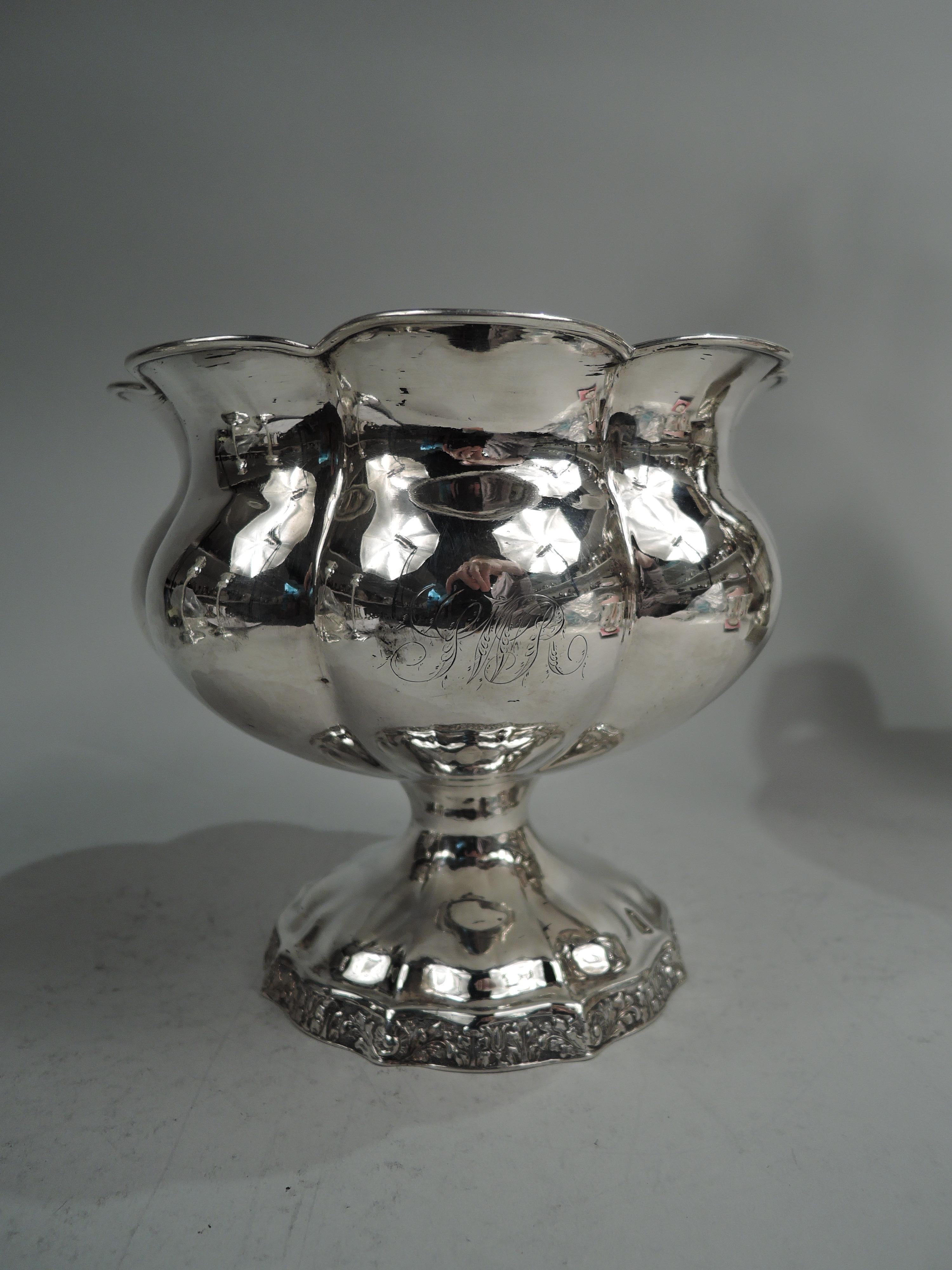 Classical coin silver bowl. Made by Thomas Fletcher in Philadelphia, ca 1830. Round and lobed with flared and scalloped petal rim on raised foot. Foot rim has leaf, shell, and flower ornament on stippled ground. Engraved script monogram. Visible