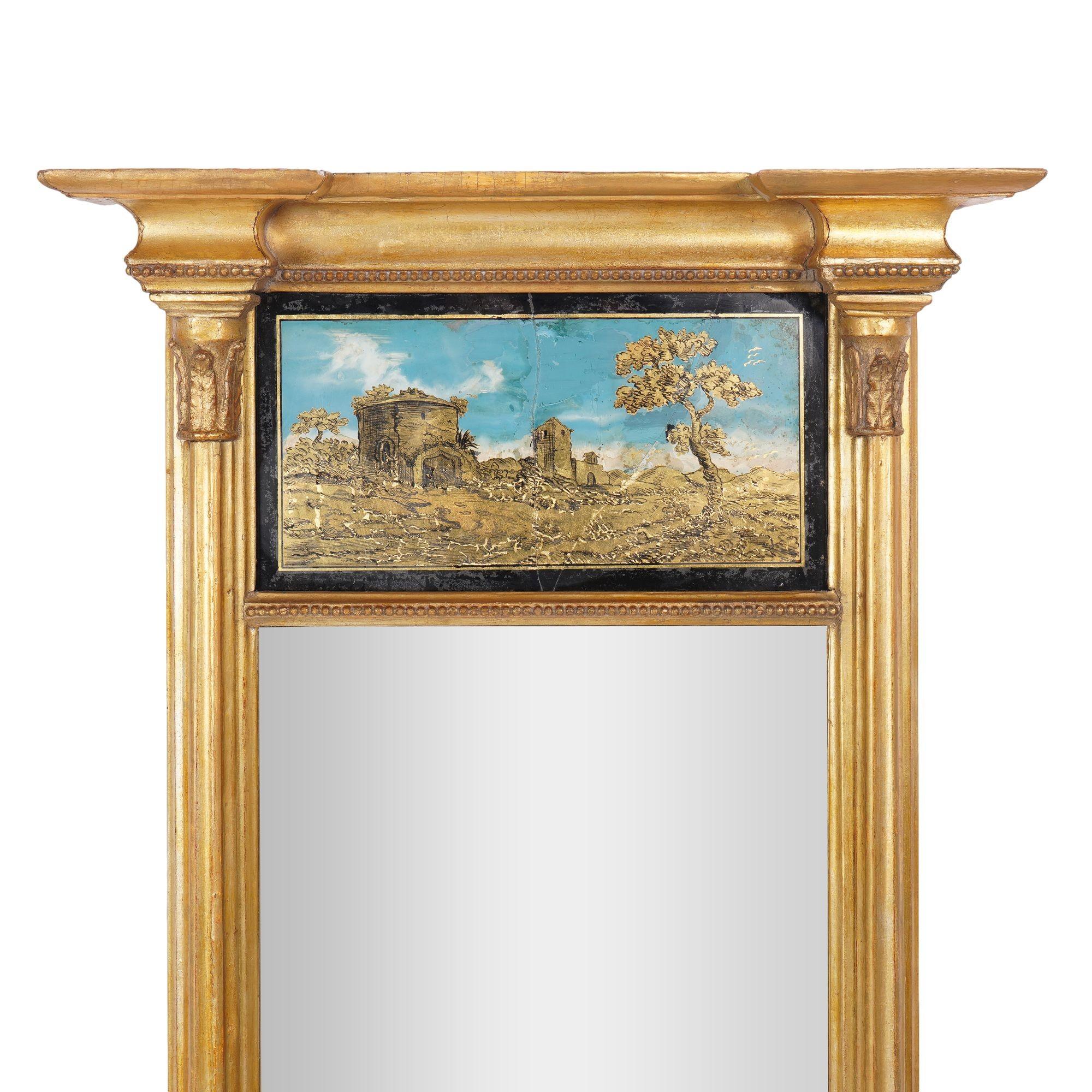 Cornice a specchio dorata a tabernacolo americano con pannello di paesaggio eglomise. Il cornicione sporgente è sorretto da semicolonne su blocchi angolari a plinto, uniti da un'inferriata ad ogiva con lunetta a gadroon.
Filadelfia, circa 1815.