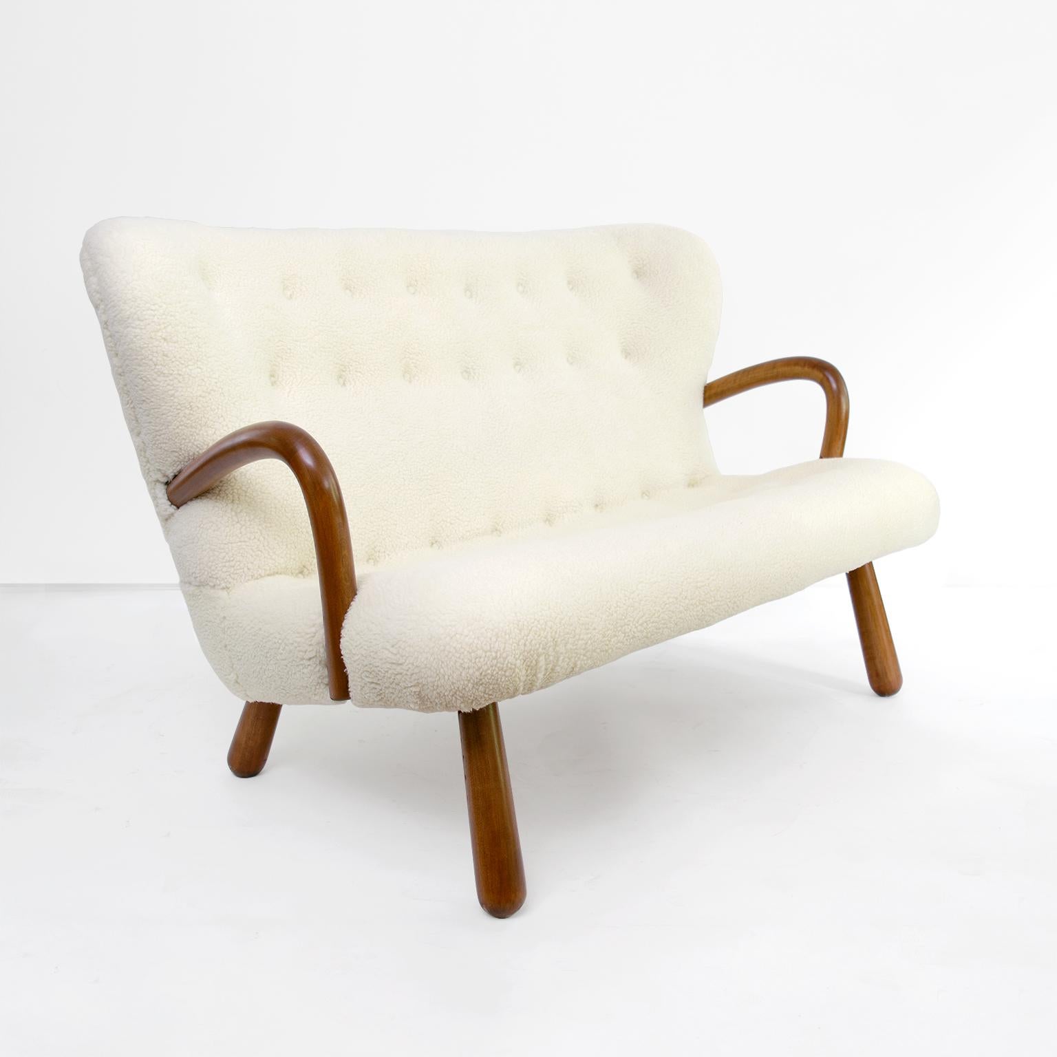 Scandinavian Modern settee attribute to Phillip Arctander and first introduced circa 1944 and produced by Nordisk Staal & Møbel Central, Denmark. The settee is constructed of stained beech wood and has been newly restored and reupholstered in