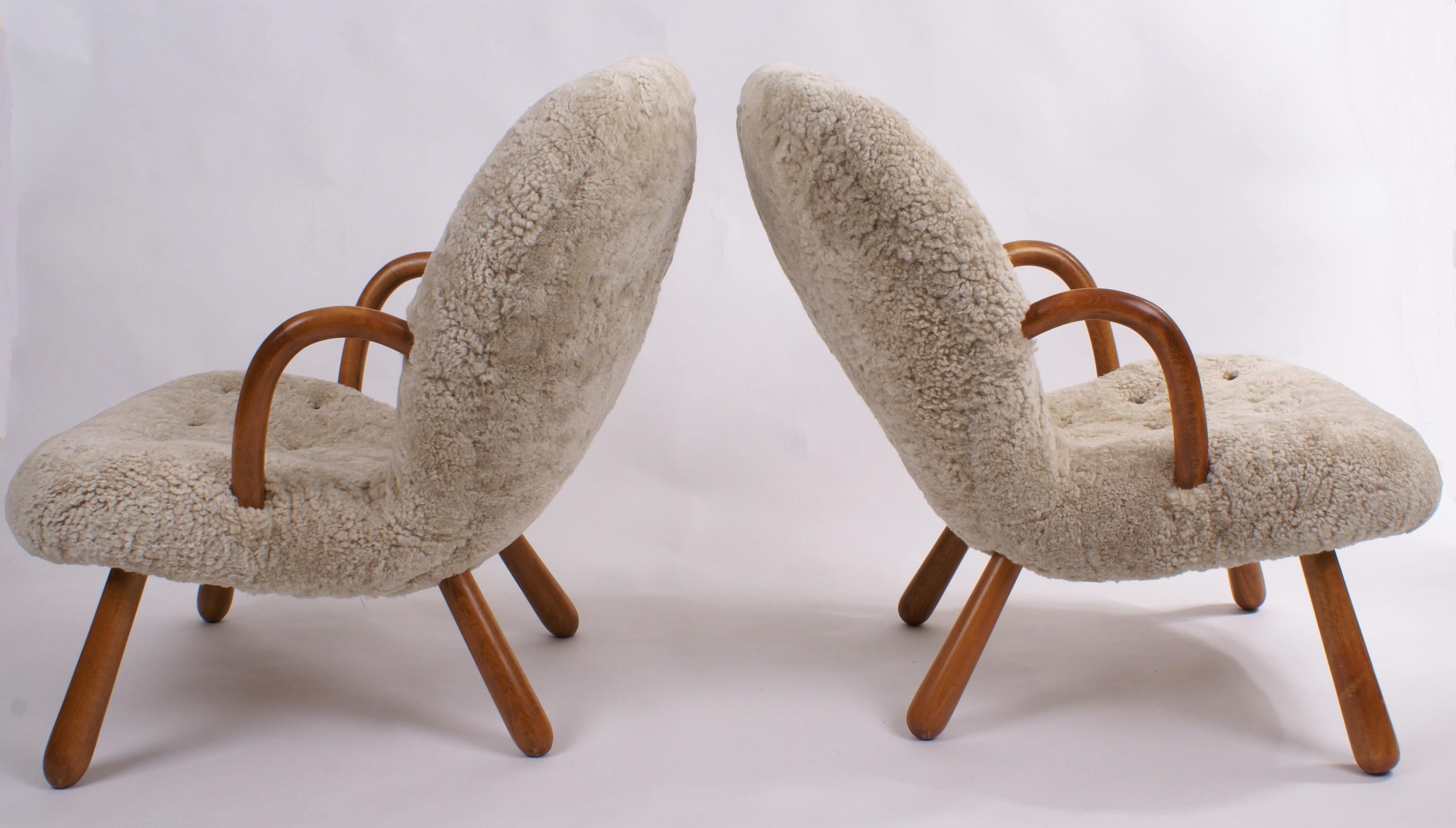 Pair of Philip Arctander 'clam' easy chairs in newly reupholstered beige sheepskin and stained beech legs and armrests. Buttons in leather. Designed, 1944.

The chairs are newly refinished and reupholstered in sheepskin.

Price is for the pair.