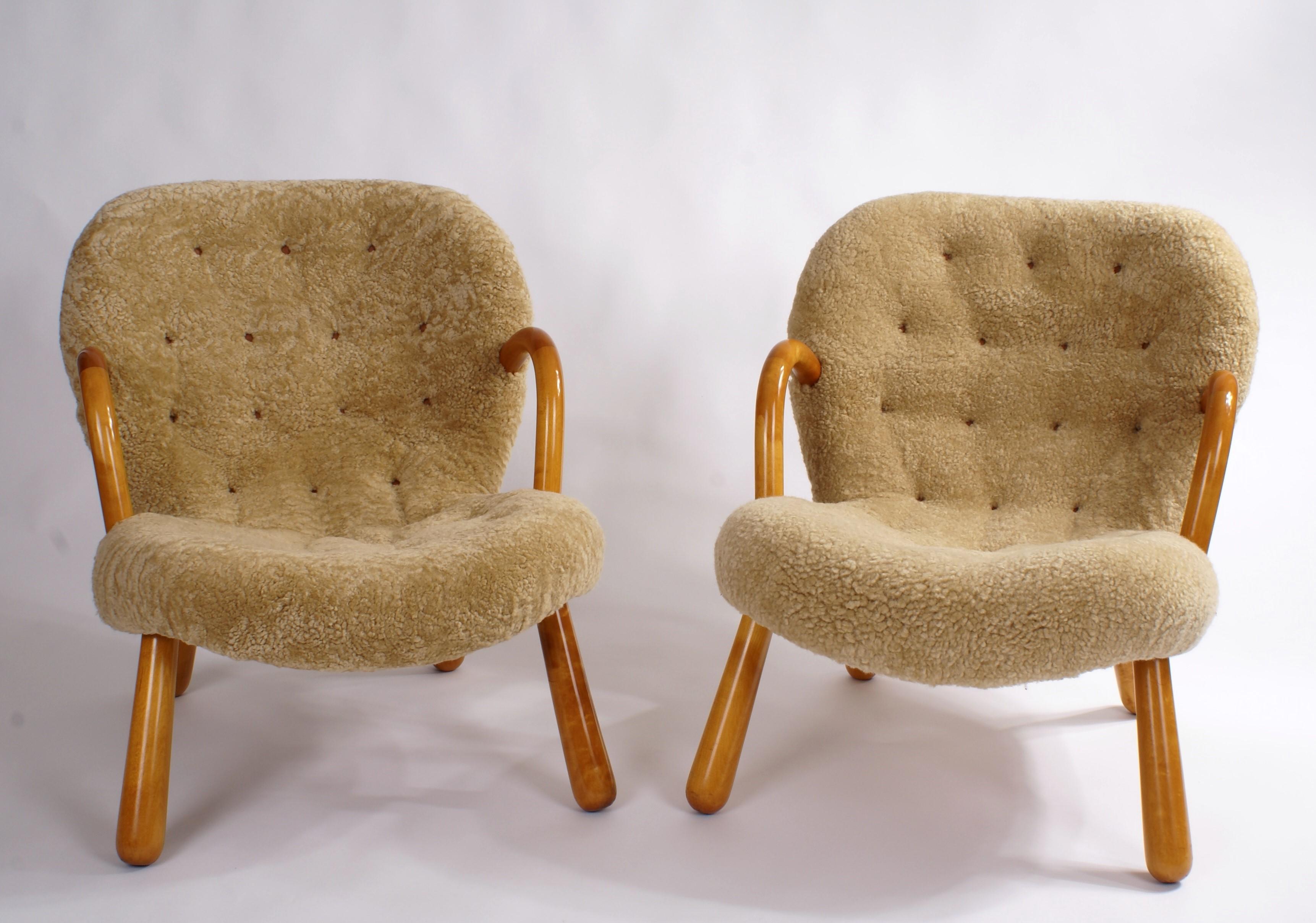 Pair of Philip Arctander 'clam' easy chairs in honey/natural coloured sheepskin and beech legs and armrests. Buttons in natural leather. Designed 1944.

The chairs are newly refinished and reupholstered in sheepskin.

Price is for the