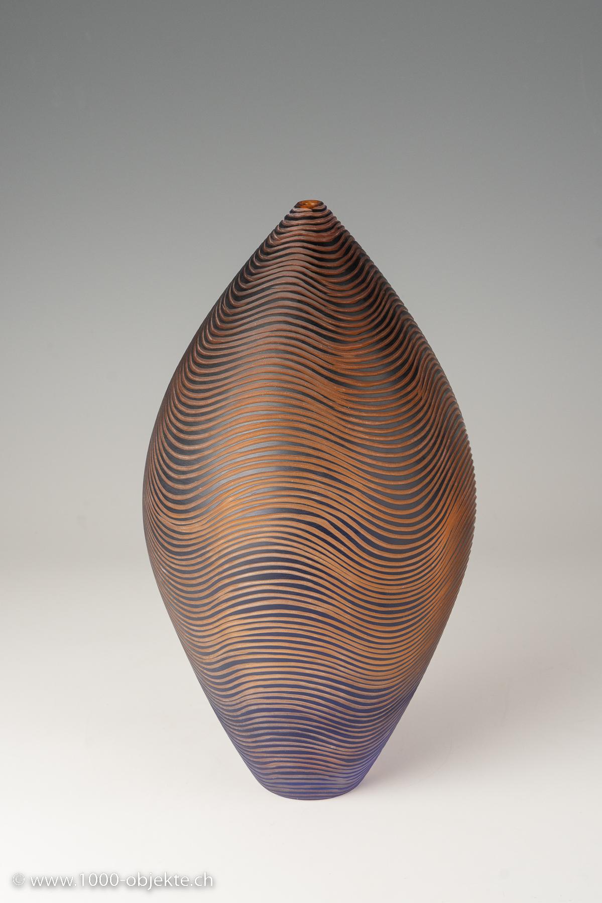 Philip Baldwin (*1947) y Monica Guggisberg (*1955)
pieza única H. 38 cm. Fabricado por Baldwin Guggisberg, Gales. Vidrio incoloro, rosa salmón y azul opaco, grabado con líneas onduladas. Marcado B/G Nonfoux '98 # B 882 (grabado).

Excelente estado