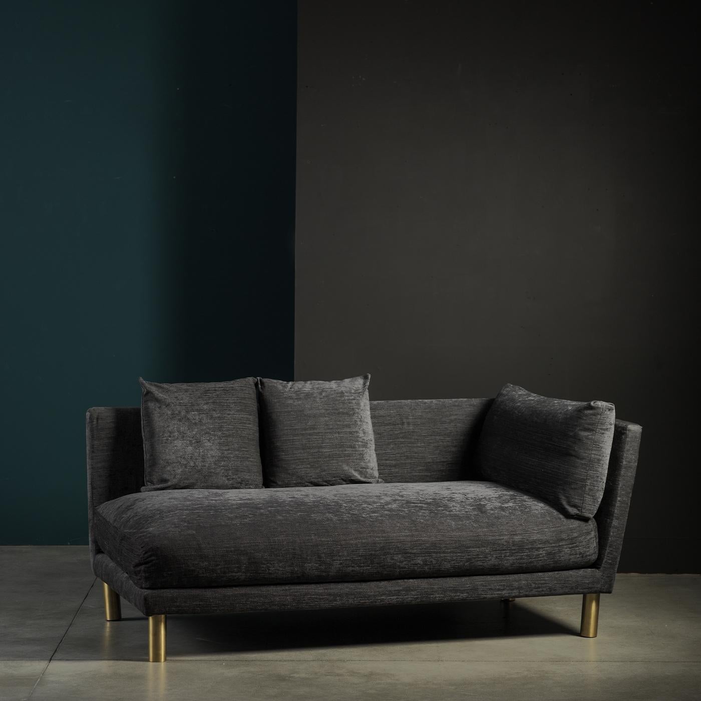 This comfortable, stylish chaise lounge makes a striking addition to any environment. It stands upon satin brass feet and is covered in soft, gray fabric. Its one-armed look is sleek and sophisticated, allowing it to blend in and stand out. Chelini