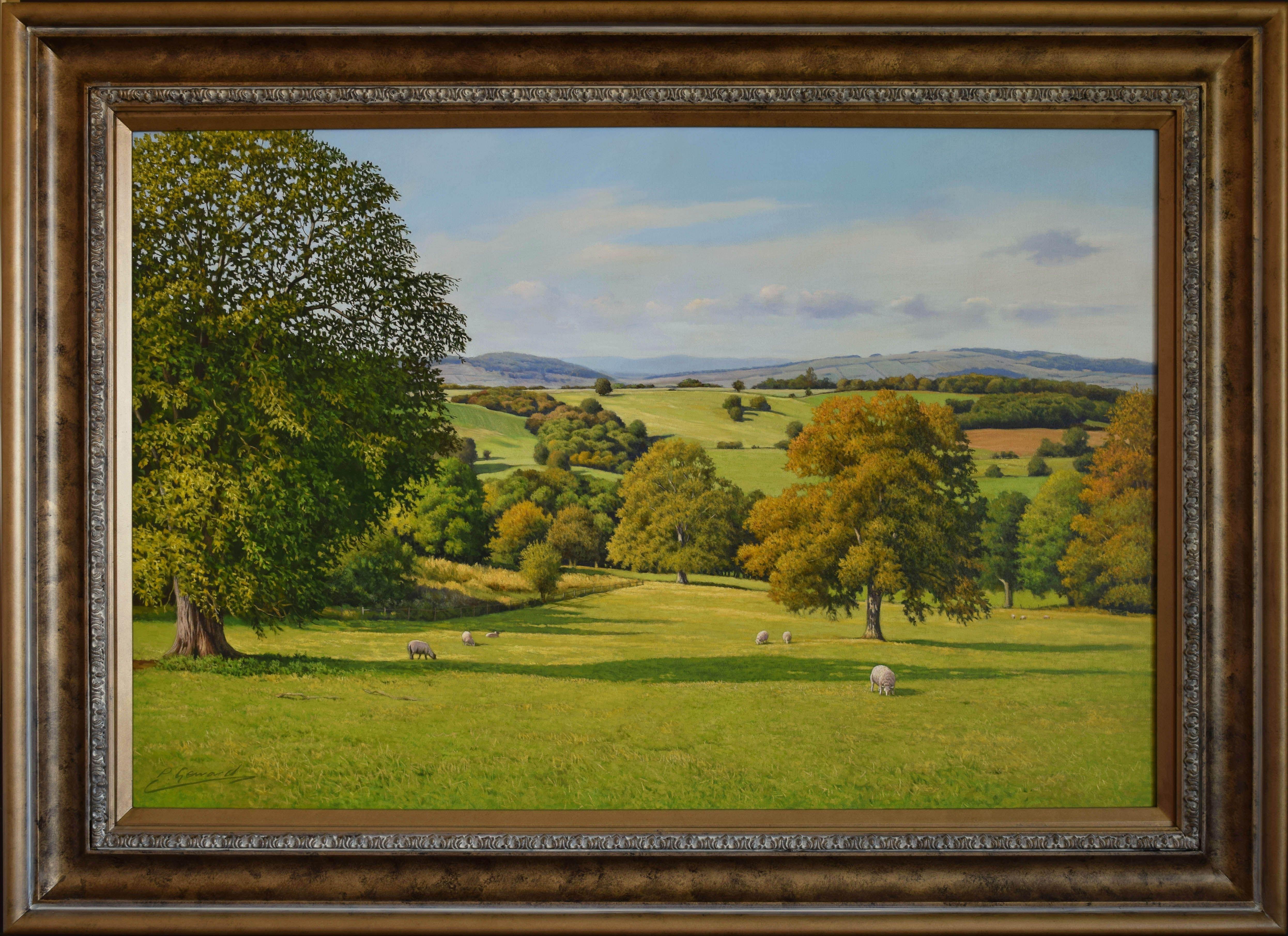 A large classical original English landscape realism oil painting which is suitable as a focal point in a room. The panoramic view across a Cotswold hillside and beyond is framed by trees and there are sheep grazing in the pasture. The subtle soft
