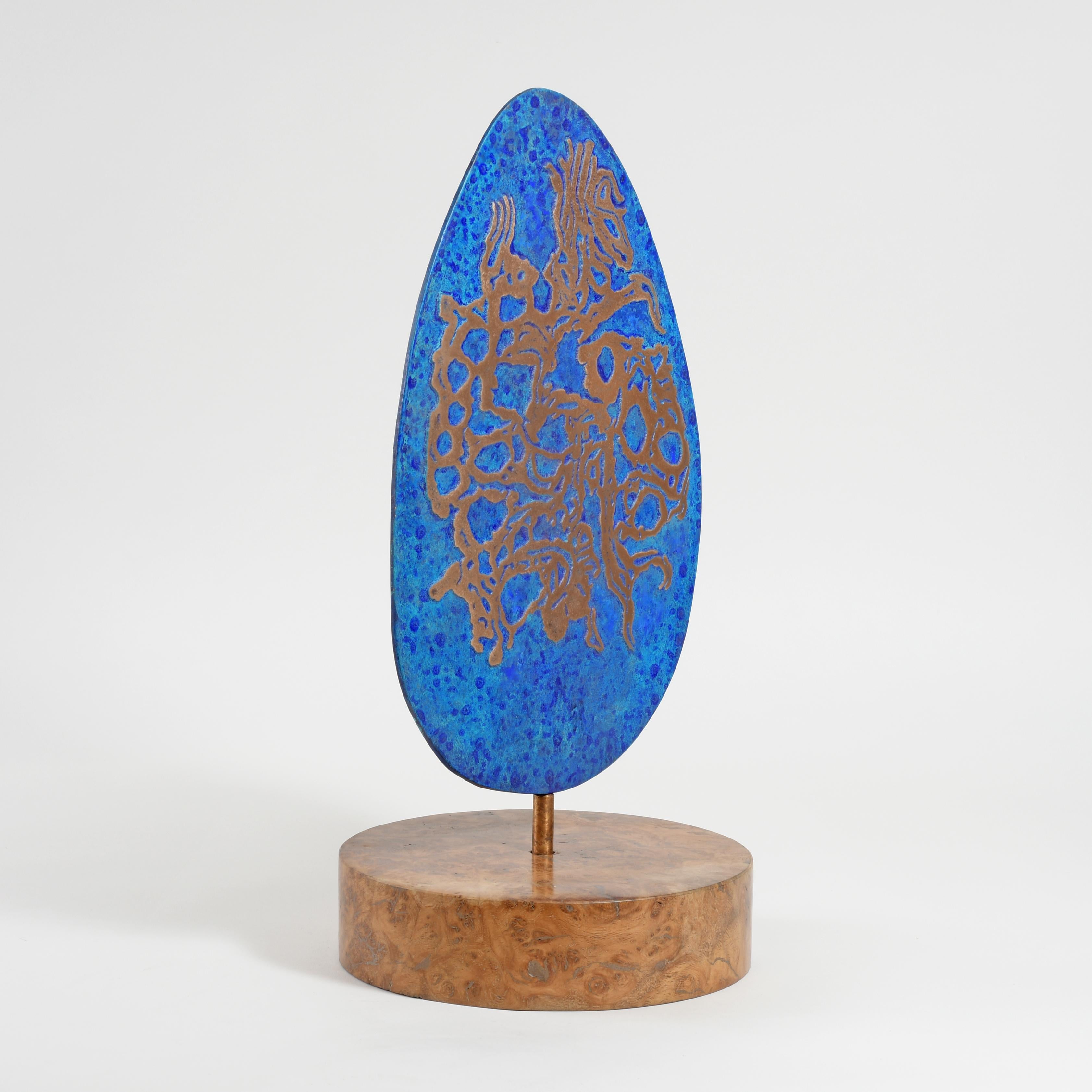 Bronze rotating on a burr oak base
Series of variations.
Stamped with monogram signature and uniquely numbered 734A
On the face the raised pattern in natural bronze is finely rubbed and lacquered and is surrounded by a blue patination and colourwash