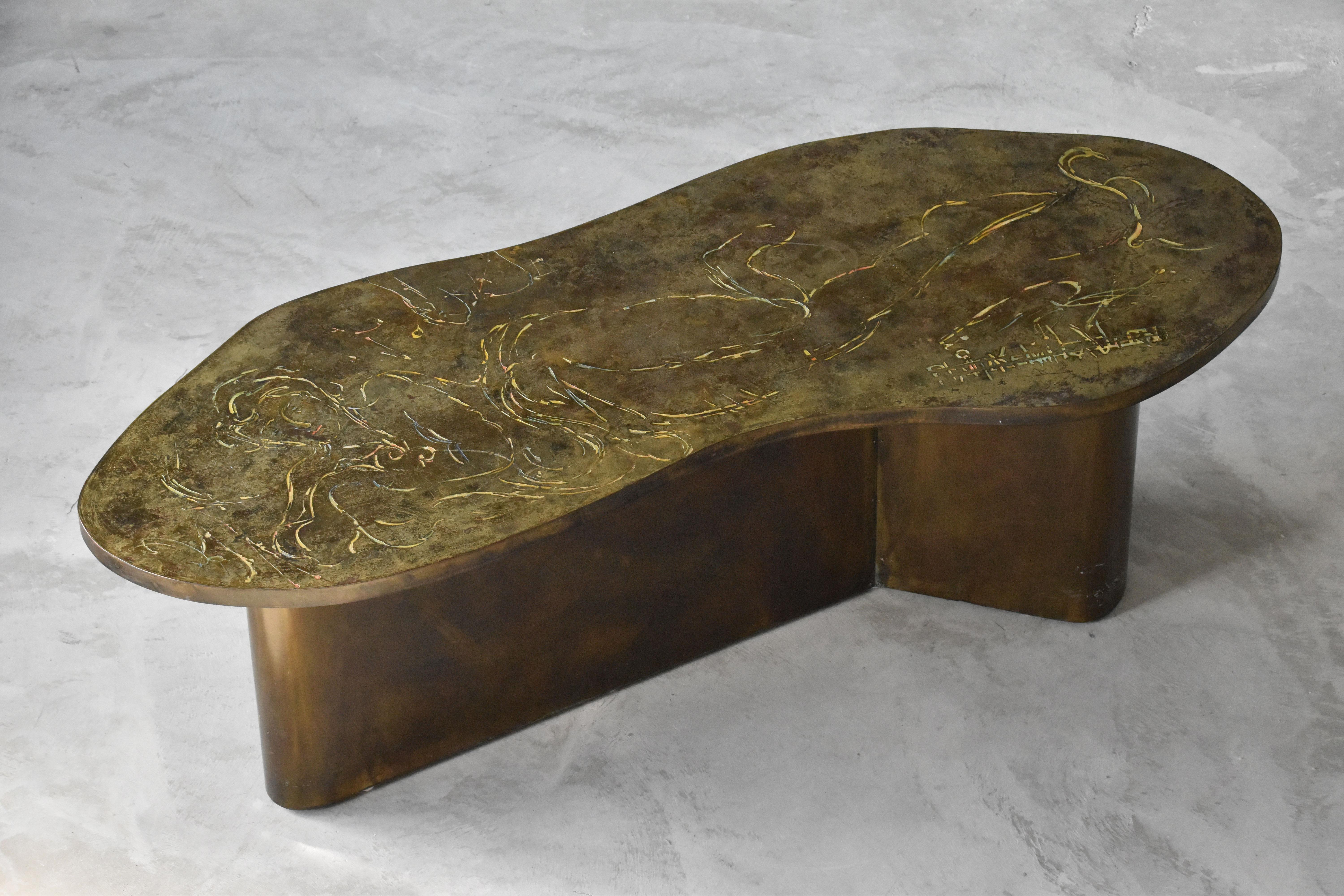 A studio-produced freeform coffee / cocktail table by Philip & Kelvin LaVerne. Produced in acid-etched and patinated brass over pewter and wood. Top with engraved motif of Leda and the Swan. Artists signature is engraved in the top. 

Artists